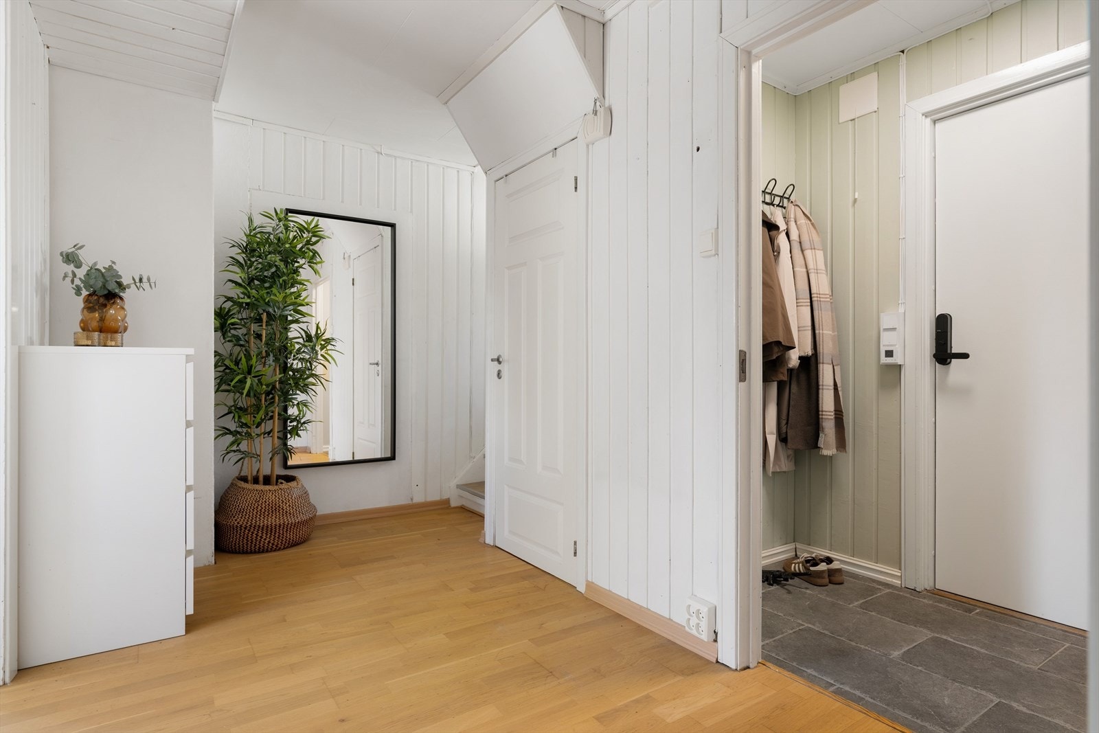 Her møter du en flislagt entre med varmekabler. Her har du god plass til klesoppheng. Gangen deler boligen opp i bad, stue/kjøkken, trapp opp og ned. Galleribilde