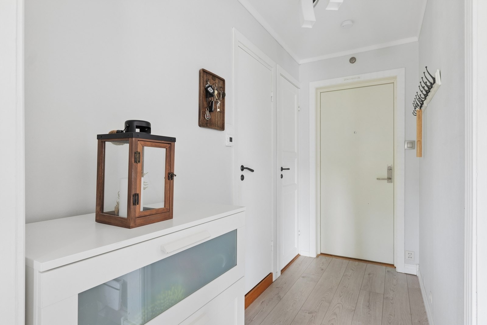 Entréen har laminatgulv lagt i 2019 og leder videre inn i leilighetens åpne oppholdsrom. Galleribilde