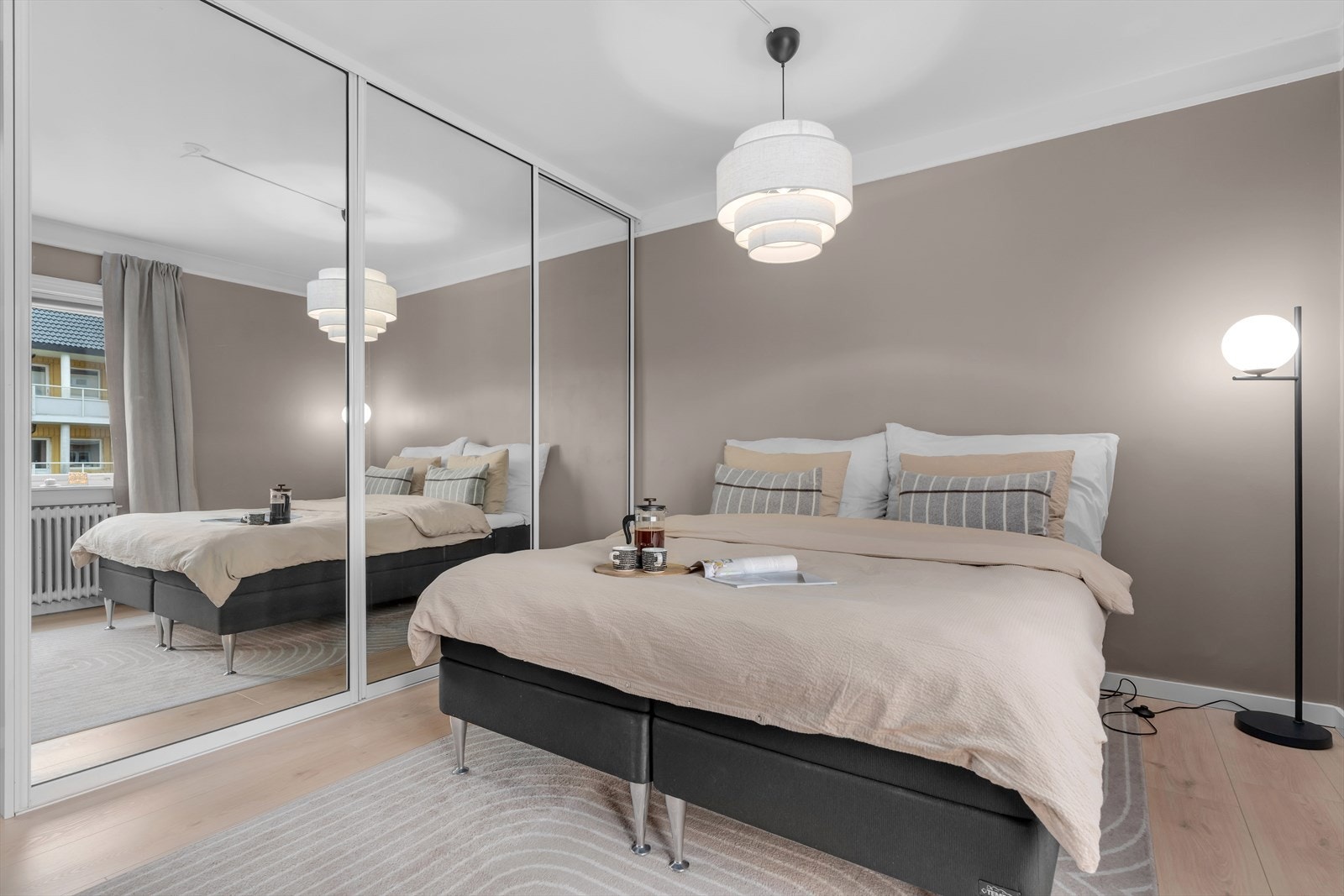 Hovedsoverommet er romslig og har godt med plass til en dobbeltseng. Langs den ene veggen finner du en praktisk, innebygd skyvedørsgarderobe med speilfronter, som både gir rikelig oppbevaringsplass og tilfører rommet et lyst og luftig uttrykk. Galleribilde