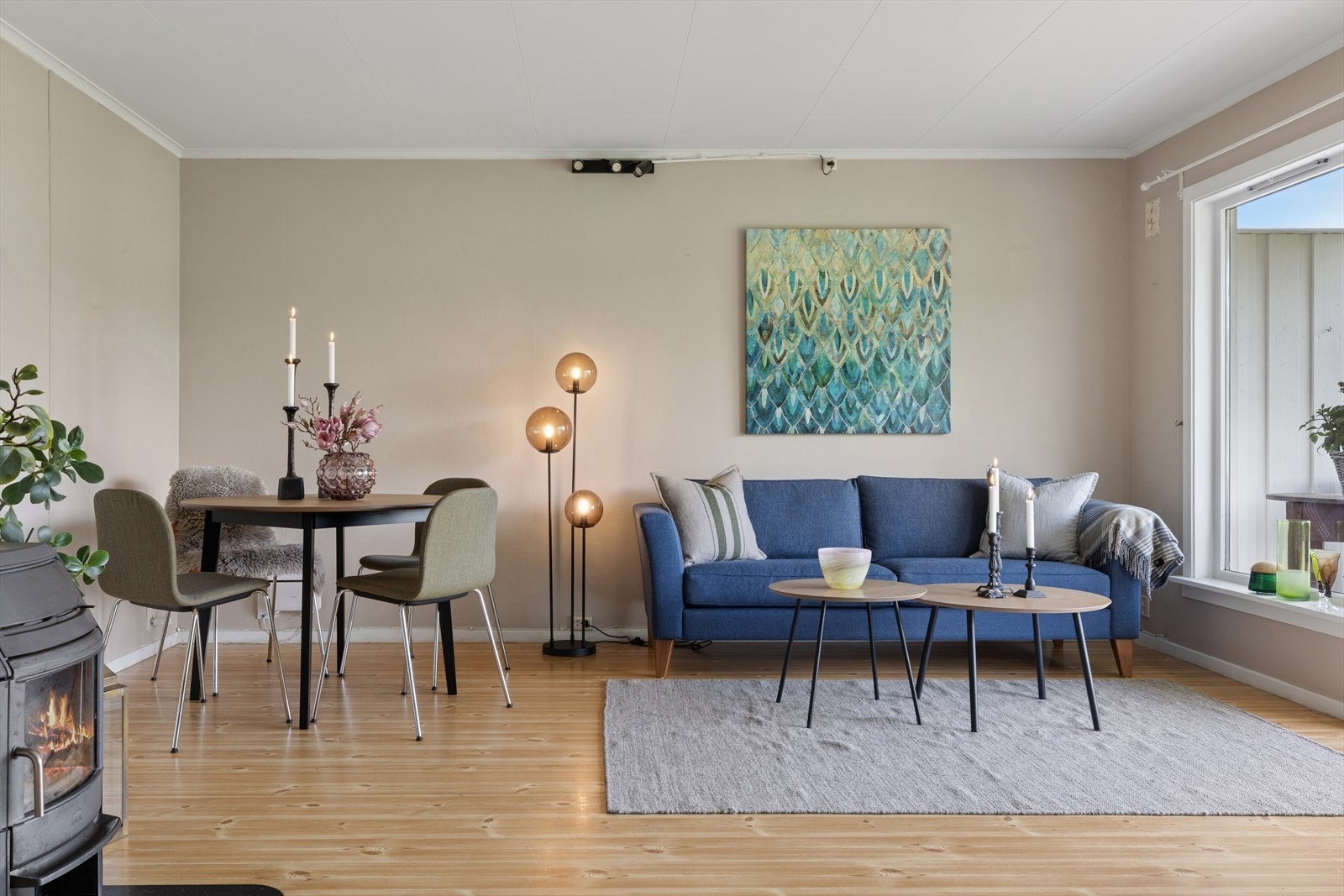 Stuen har god plass til både sofagruppe og spisebord. Peisovnen gir lun varme på kjølige dager. Galleribilde
