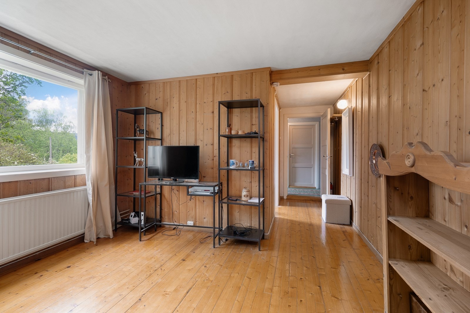 Innredet rom i underetasjen med tregulv og panel på vegger. Galleribilde