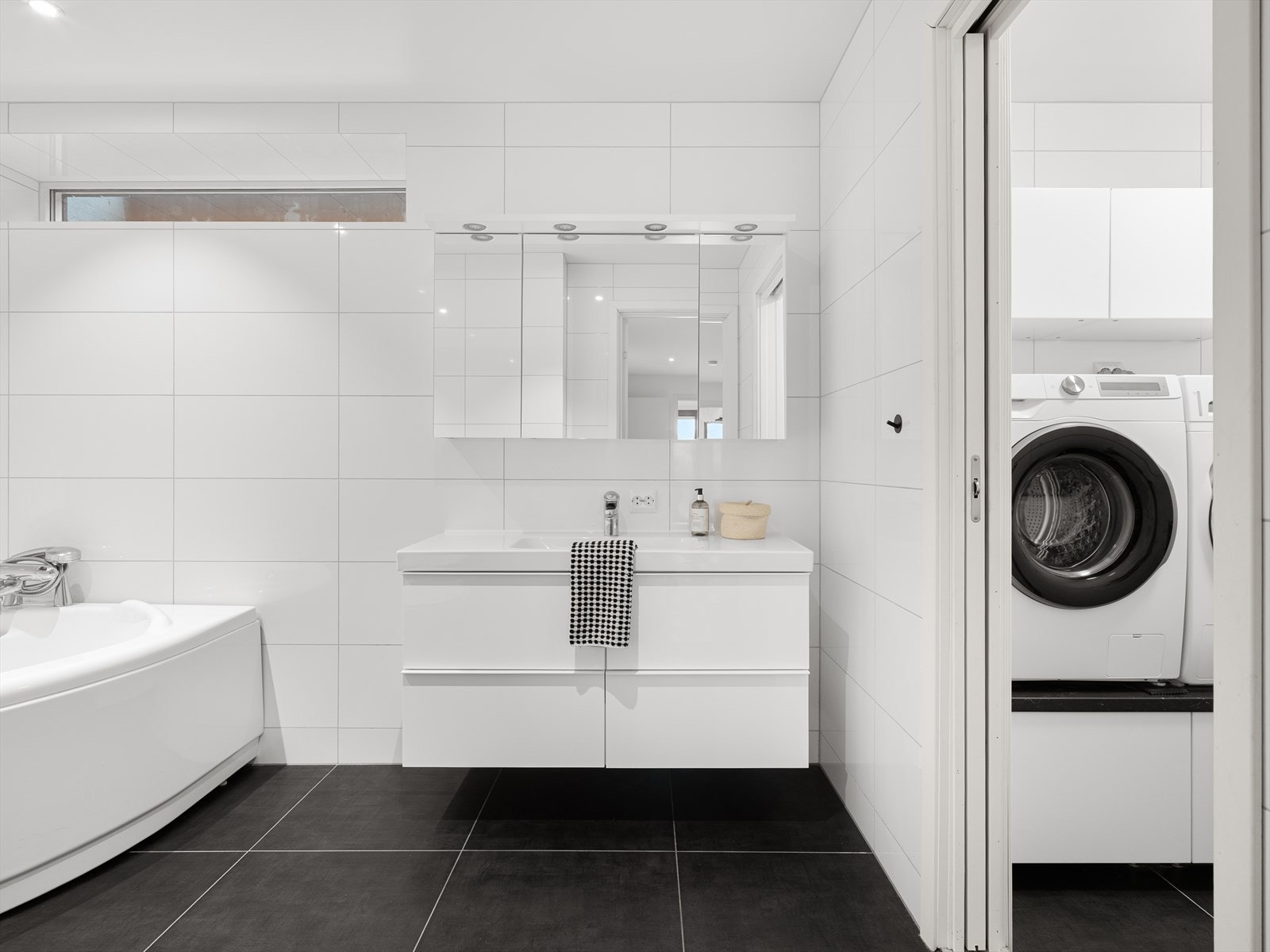Badet har flislagte overflater og god oppbevaringsplass i speilskap og servantskap. Galleribilde