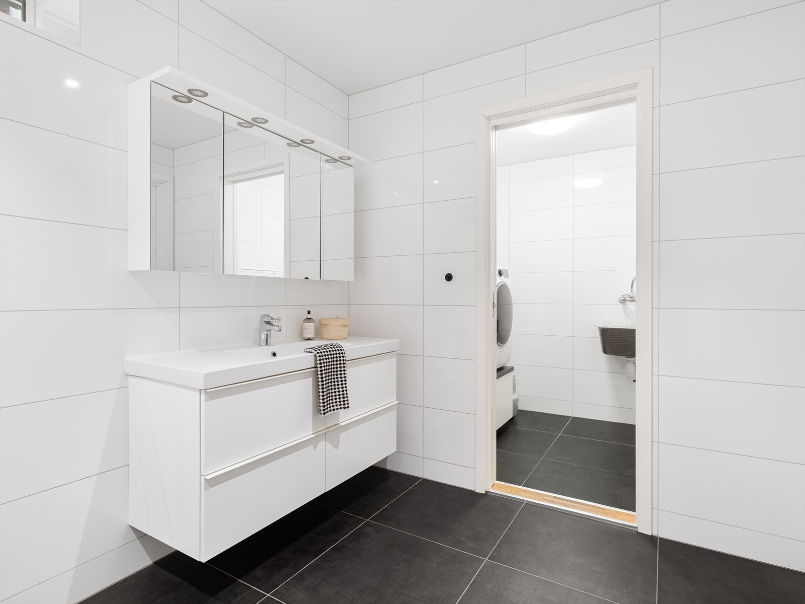 Fra badet er det praktisk adkomst til et separat vaskerom med utslagsvask og opplegg for vaskemaskin. Galleribilde