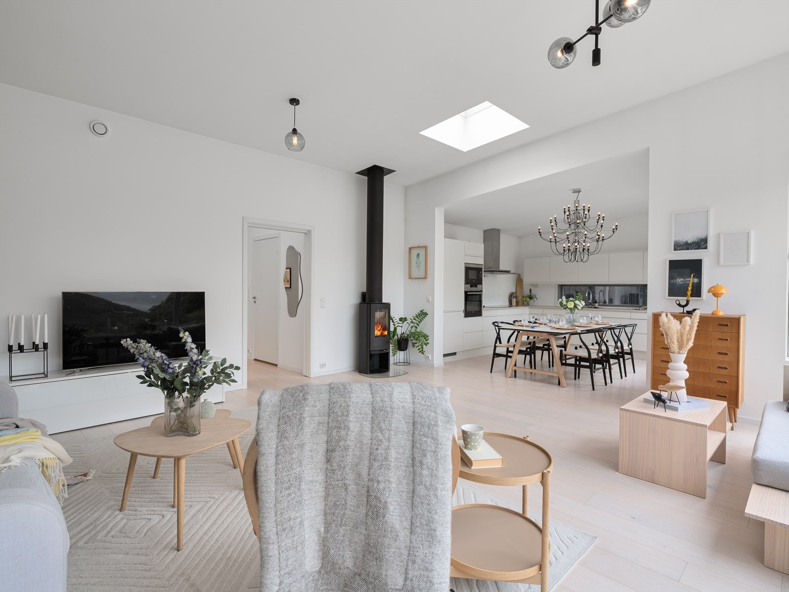 Den åpne planløsningen gir en god flyt mellom stue og kjøkken, og en vedovn sentralt plassert gir varme og hygge. Galleribilde