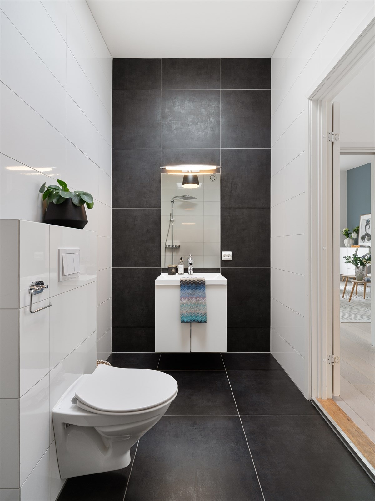 Badet i første etasje har flislagt gulv og vegger, innredning med nedfelt servant og veggmontert toalett. Galleribilde