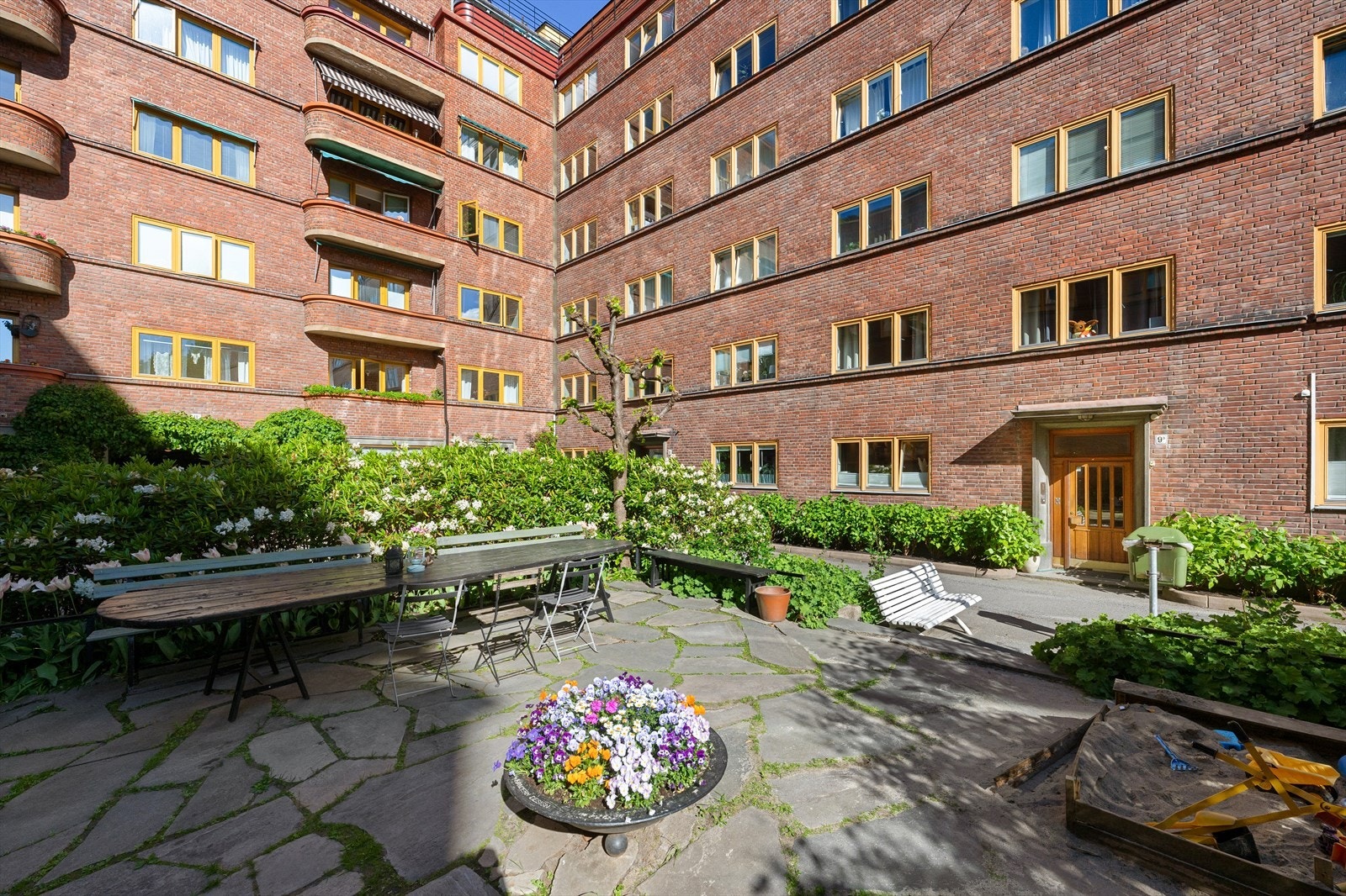 Hyggelig og skjermet gårdsrom med beplantning og felles sittegrupper. Galleribilde