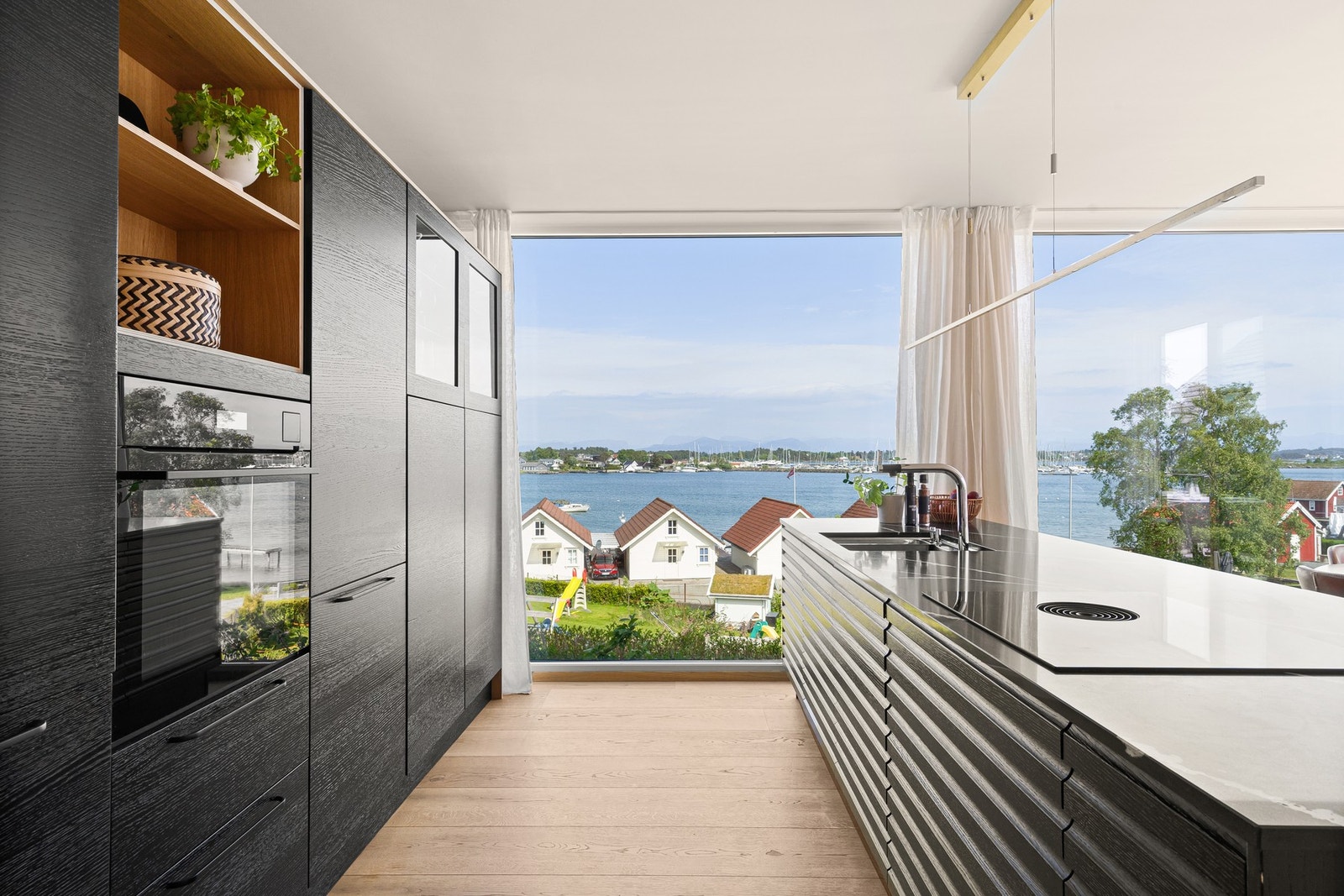 Moderne kjøkken med rikelig skapplass og benkeplate av stein. Galleribilde