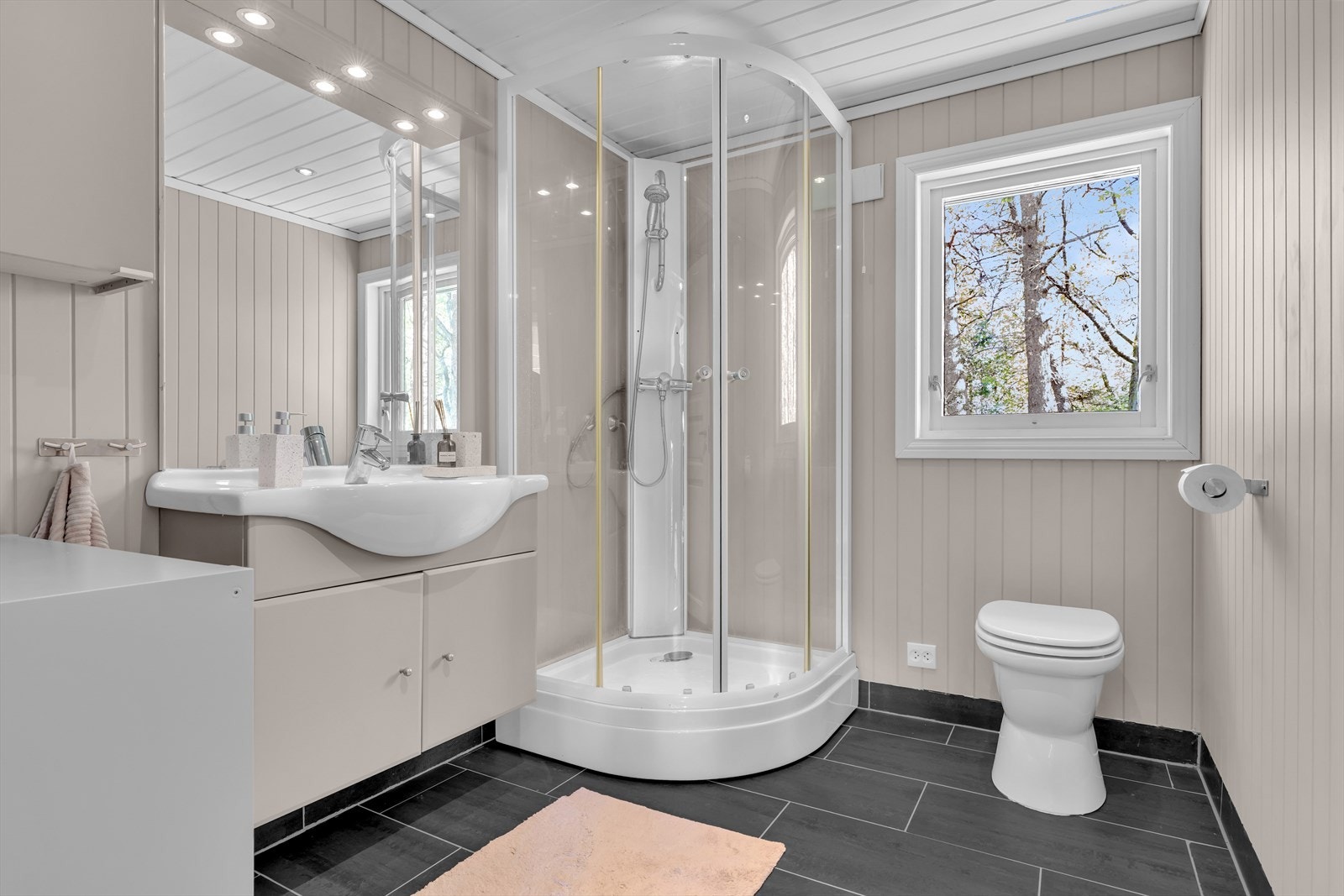 Badet har flislagt gulv med elektriske varmekabler, dusjkabinett og biologisk toalett. Galleribilde