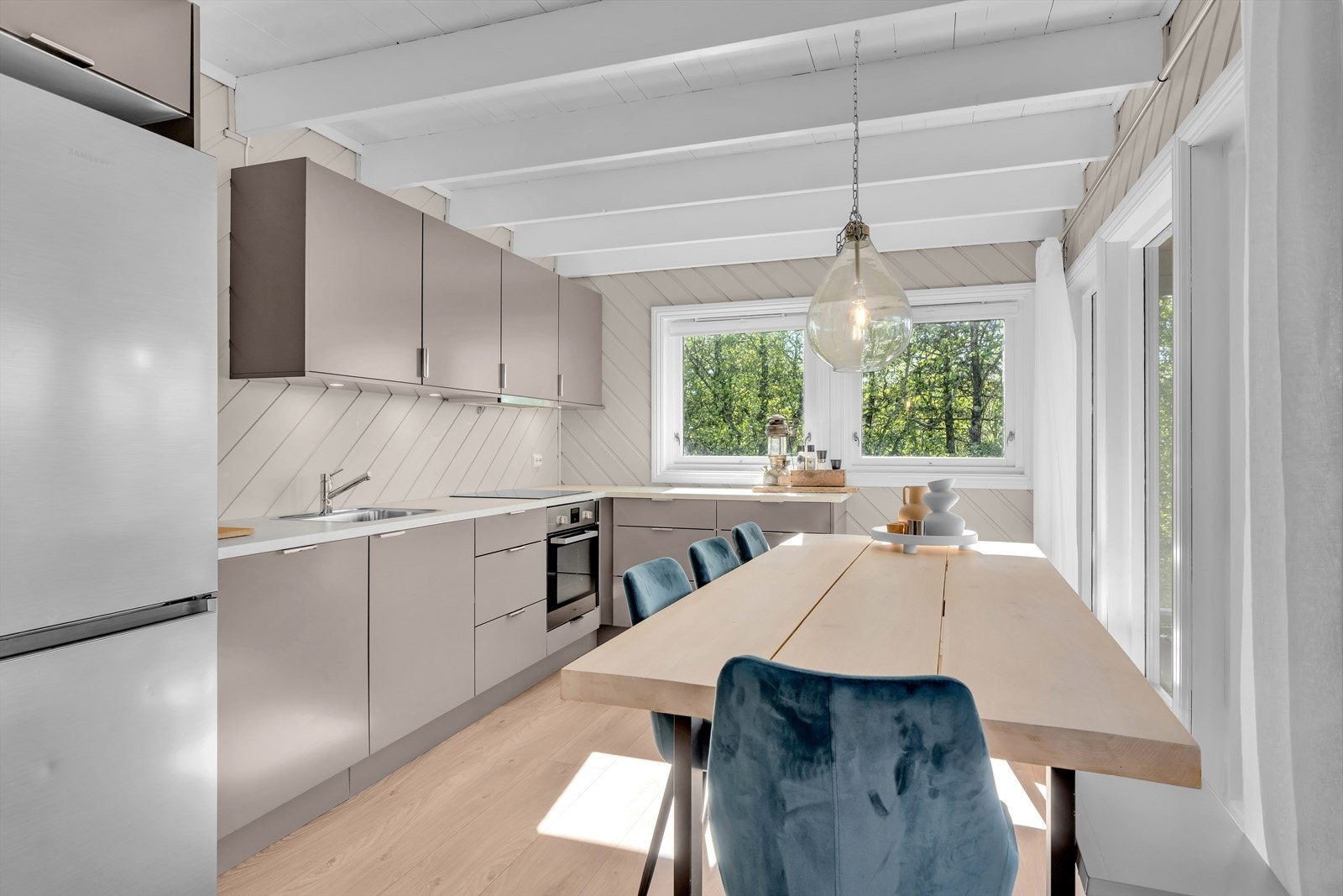 Kjøkkeninnredningen fra Strai ble montert i 2022 og har glatte fronter og laminatbenkeplate. Galleribilde