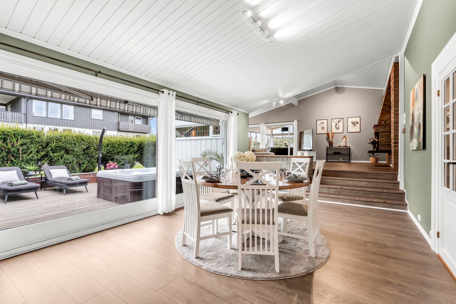 Spisestuen er stor og her er det utgang til den solrike terrassen som er omkranset med hekk Galleribilde