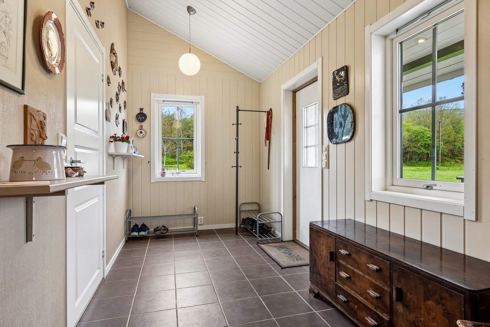 Velkommen inn til en romslig entrè/gang. Det er montert elbillader på vegg mot gårdsplass. Galleribilde