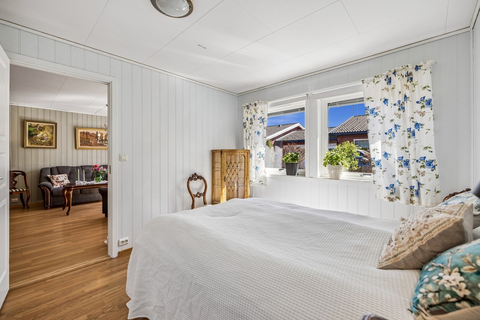 Vegger med lyst trepanel og parkett på gulvet. Galleribilde