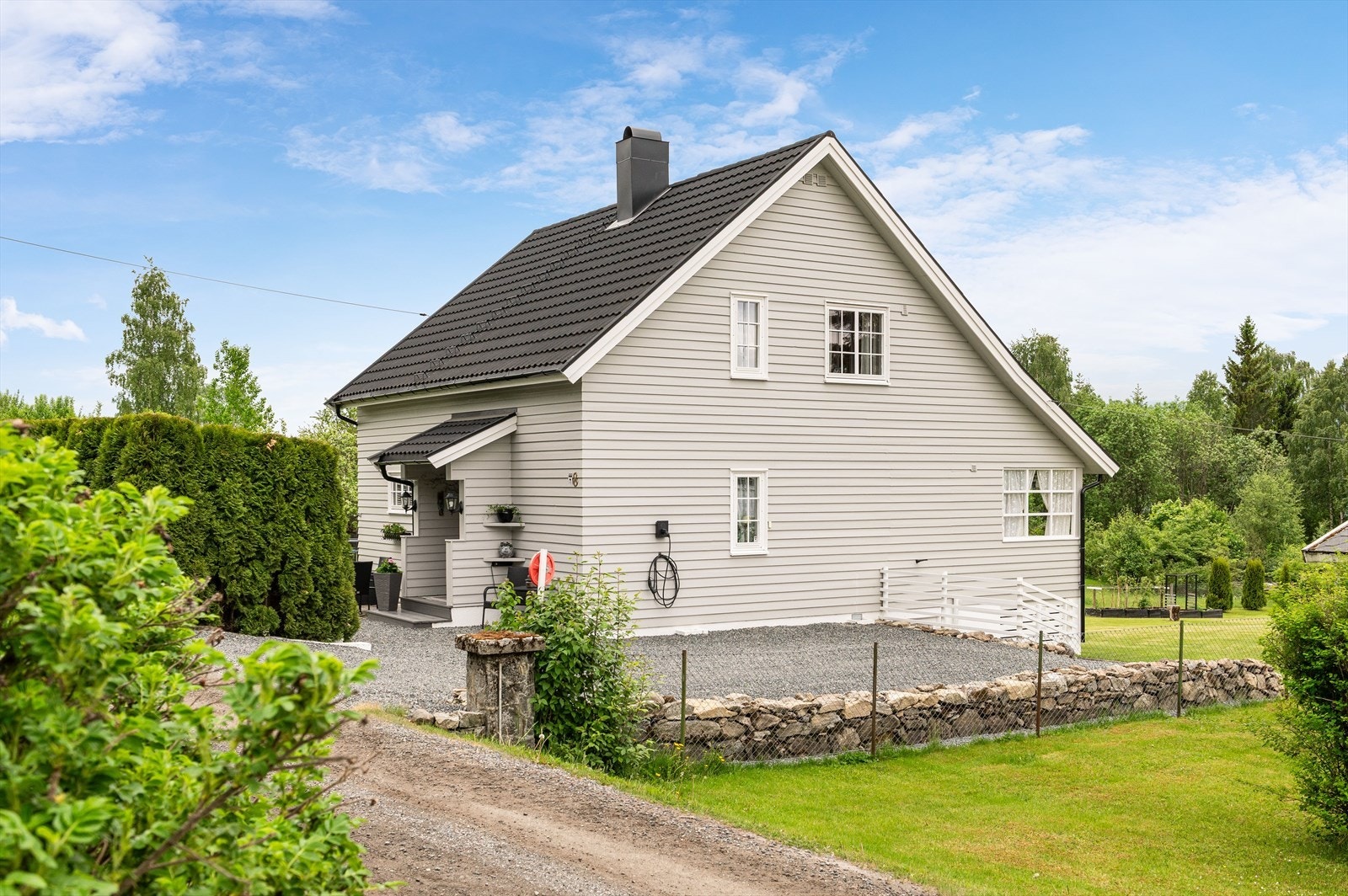 Gruset gårdsplass og elbil lader på yttervegg. Galleribilde