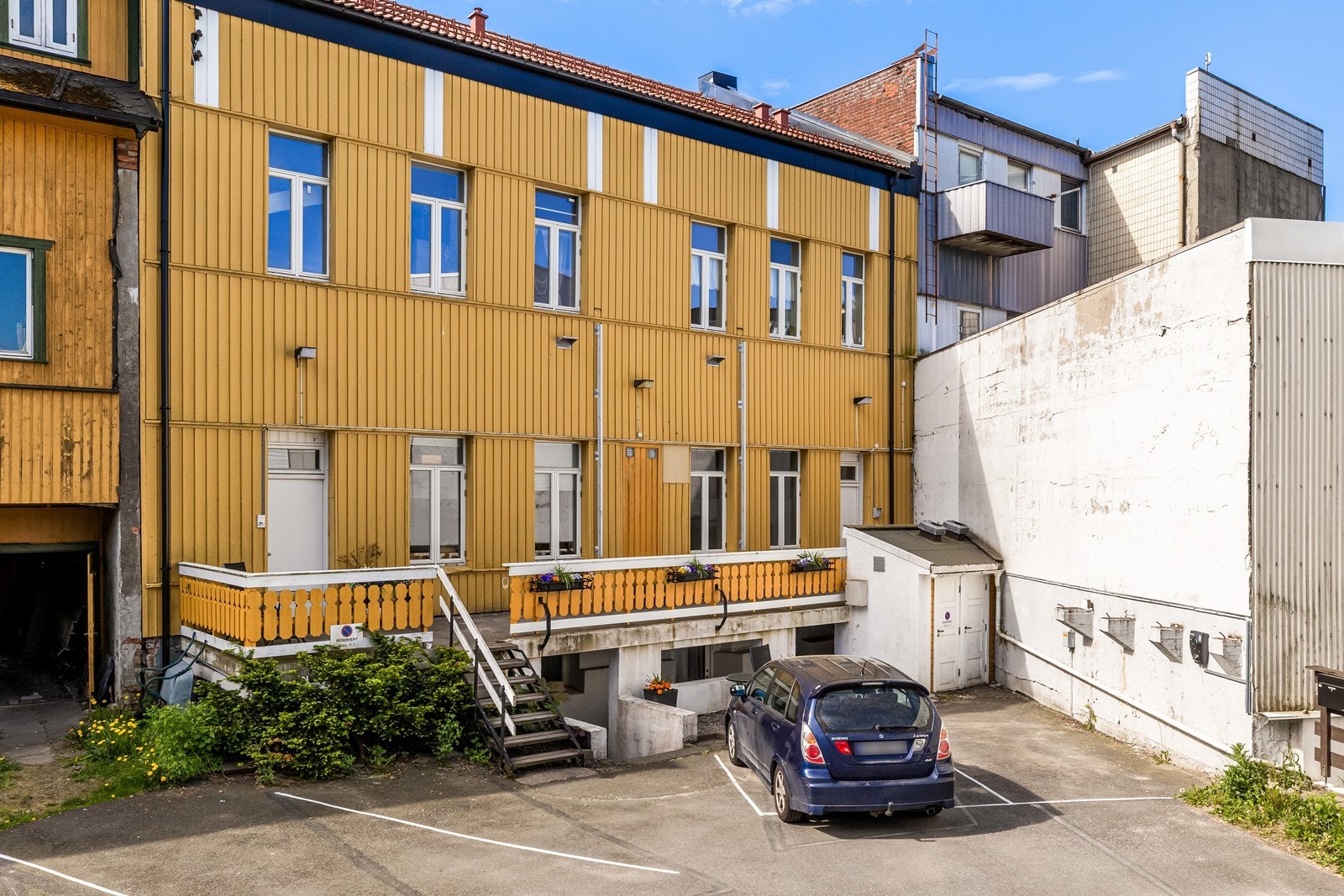 Bakgård med parkering og adkomst til boligen. Galleribilde