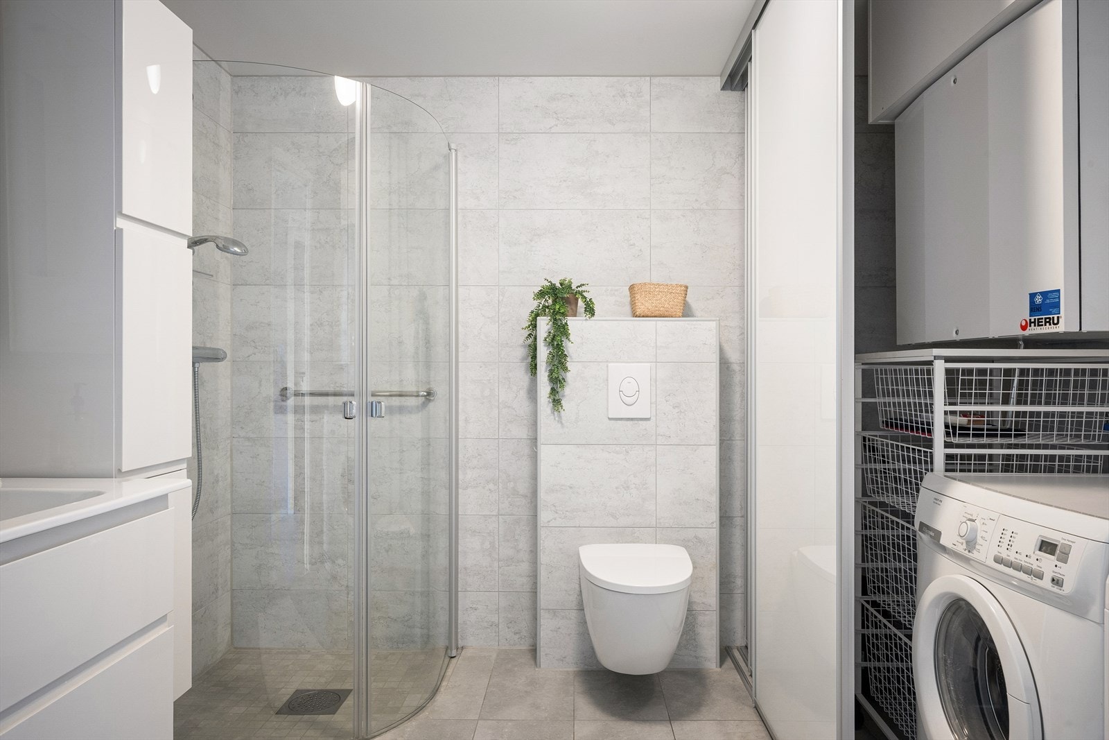 Meget kjekk løsning på badet med skyvedører som skjuler vaskemaskinen Galleribilde