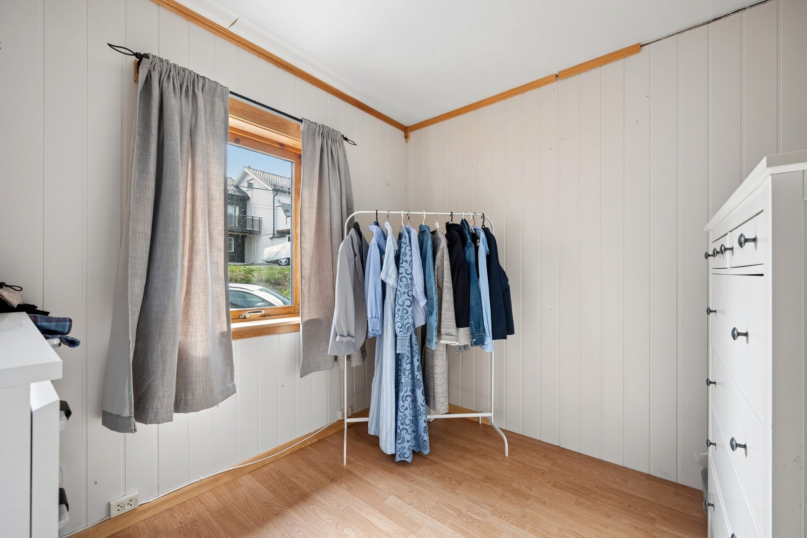Det andre soverommet i første etasje, med laminat på gulv og malte veggplater. Galleribilde