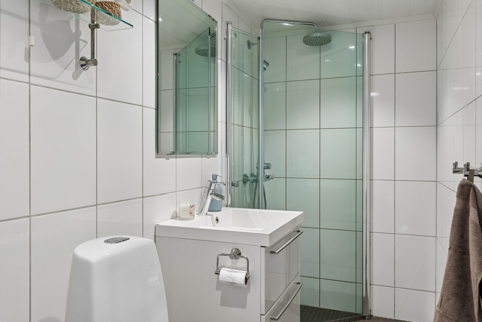 Badet fremstår som praktisk og tidløst innredet med flislagte gulv og vegger, samt behagelig gulvvarme som bidrar til god komfort i hverdagen. Galleribilde