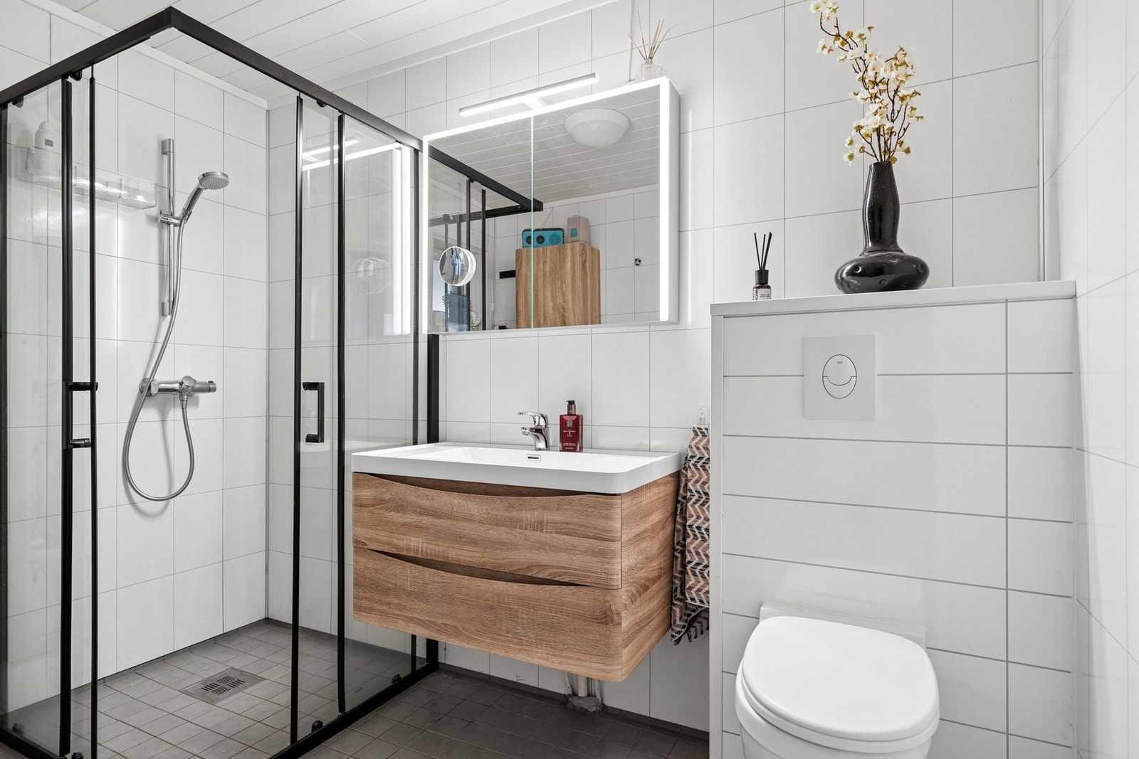 Badet i hovedetasjen er delikat innredet og har flislagt gulv med elektriske varmekabler, vegghengt toalett og dusjhjørne. Galleribilde