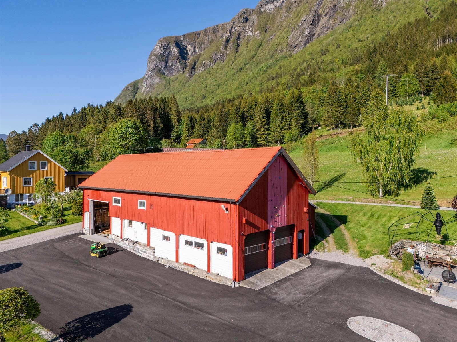 Driftsbygningen sett fra luften, med den store, asfalterte gårdsplassen foran. Galleribilde