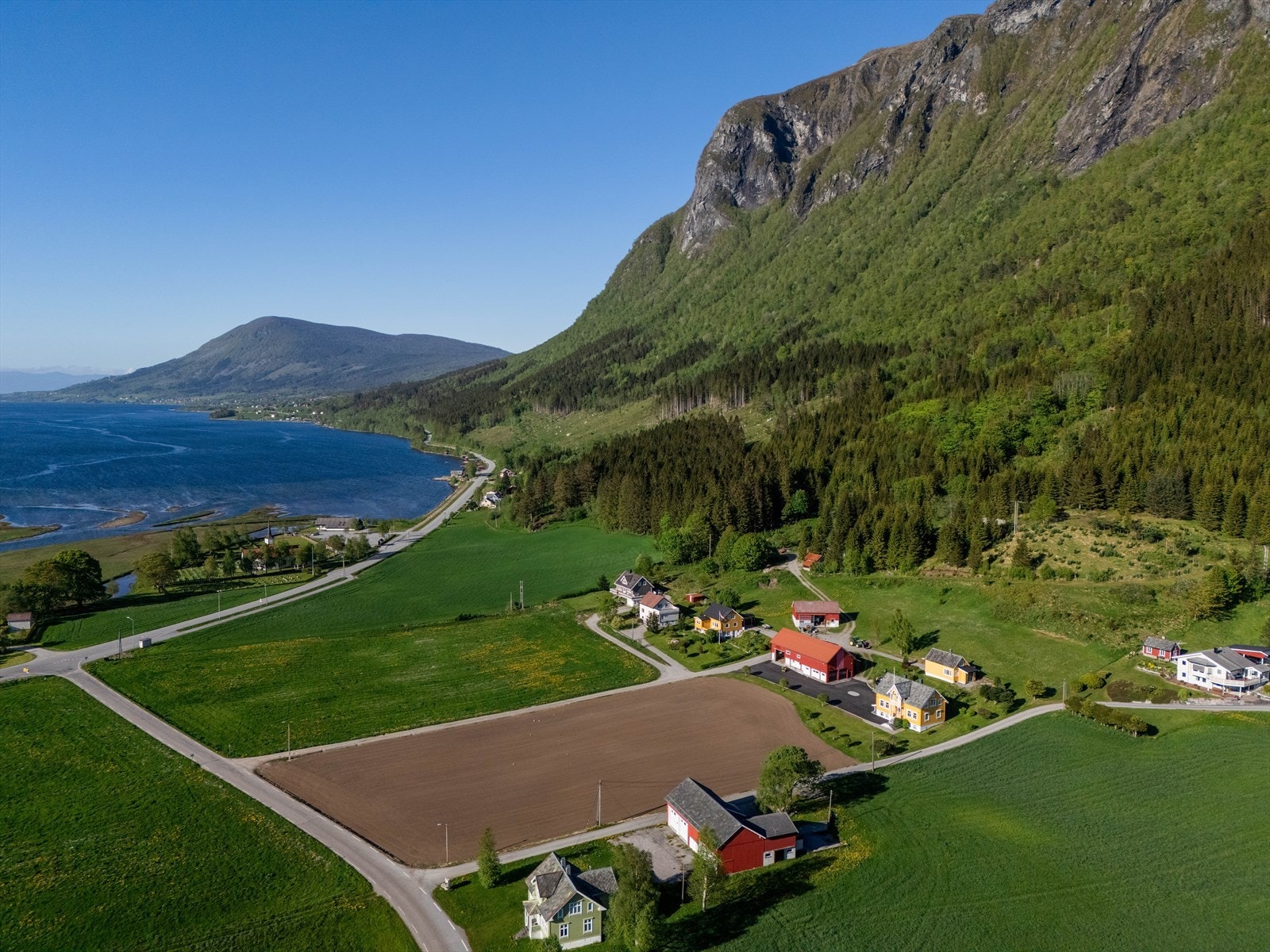 Eiendommen har en sentral, men likevel usjenert beliggenhet i bygda med nysådd eng i forkant. Galleribilde