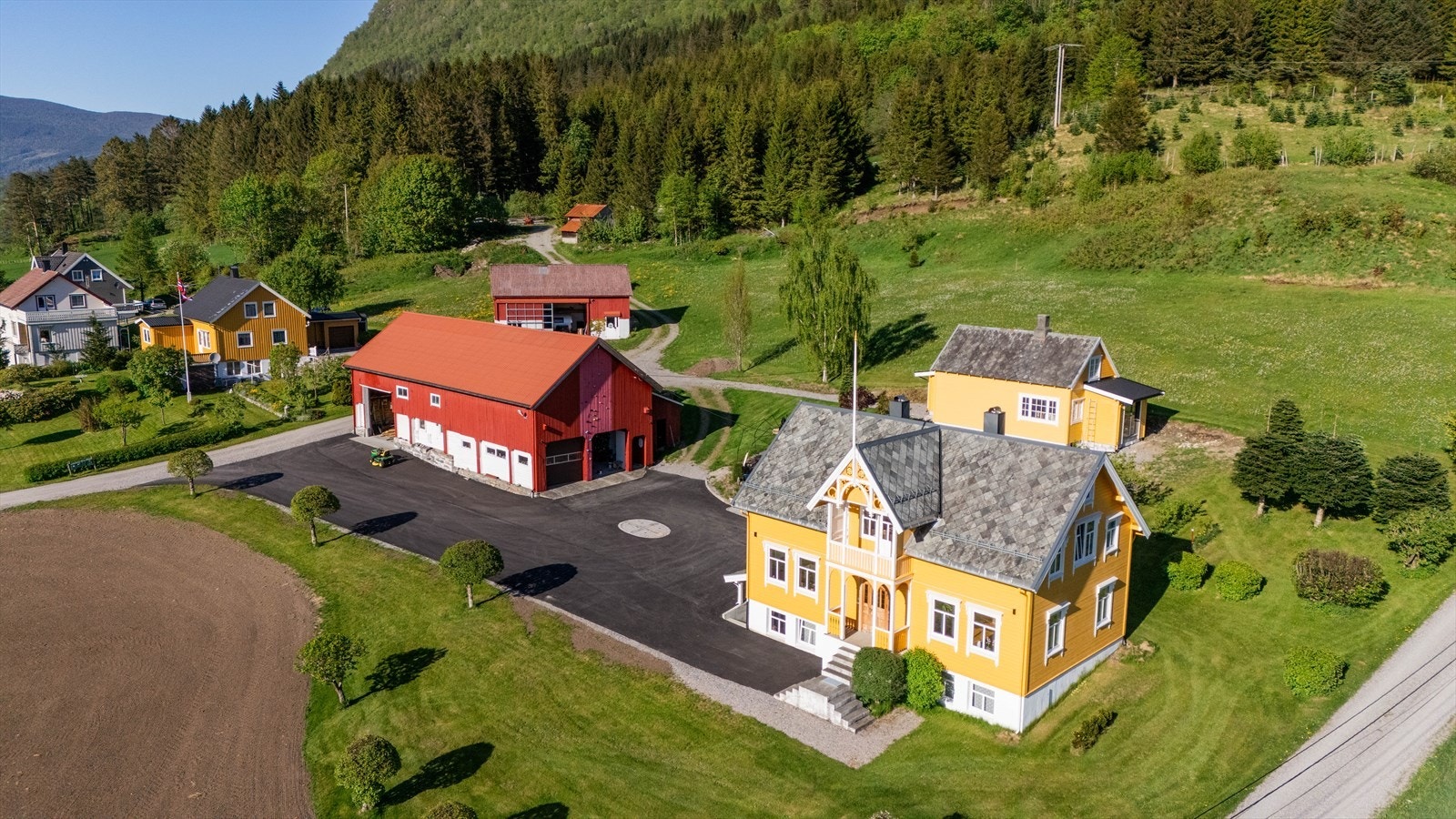 DNB Eiendom v/Bendik Joten Tangen har gleden av å presentere Øvstedalsvegen 11 - Eiendommen strekker seg over et stort areal med asfaltert tun og grønne enger, omkranset av majestetiske fjell. Galleribilde