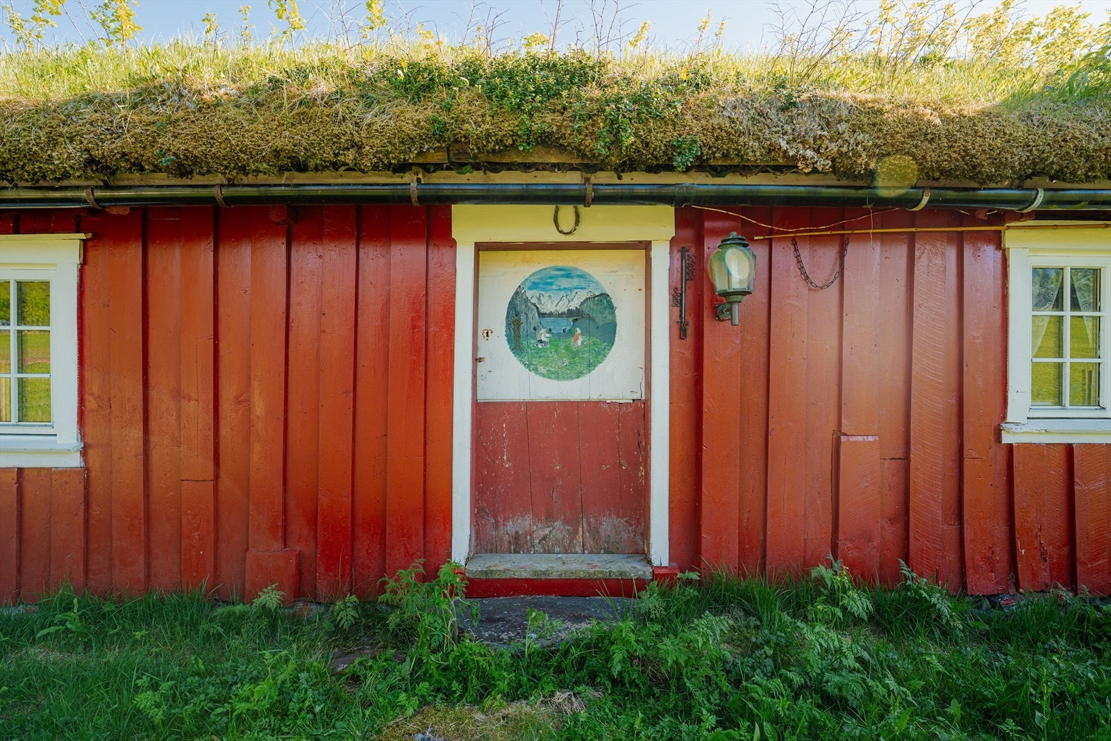 Fasaden på husmannsplassen med den karakteristiske døren og sprossevinduer. Galleribilde