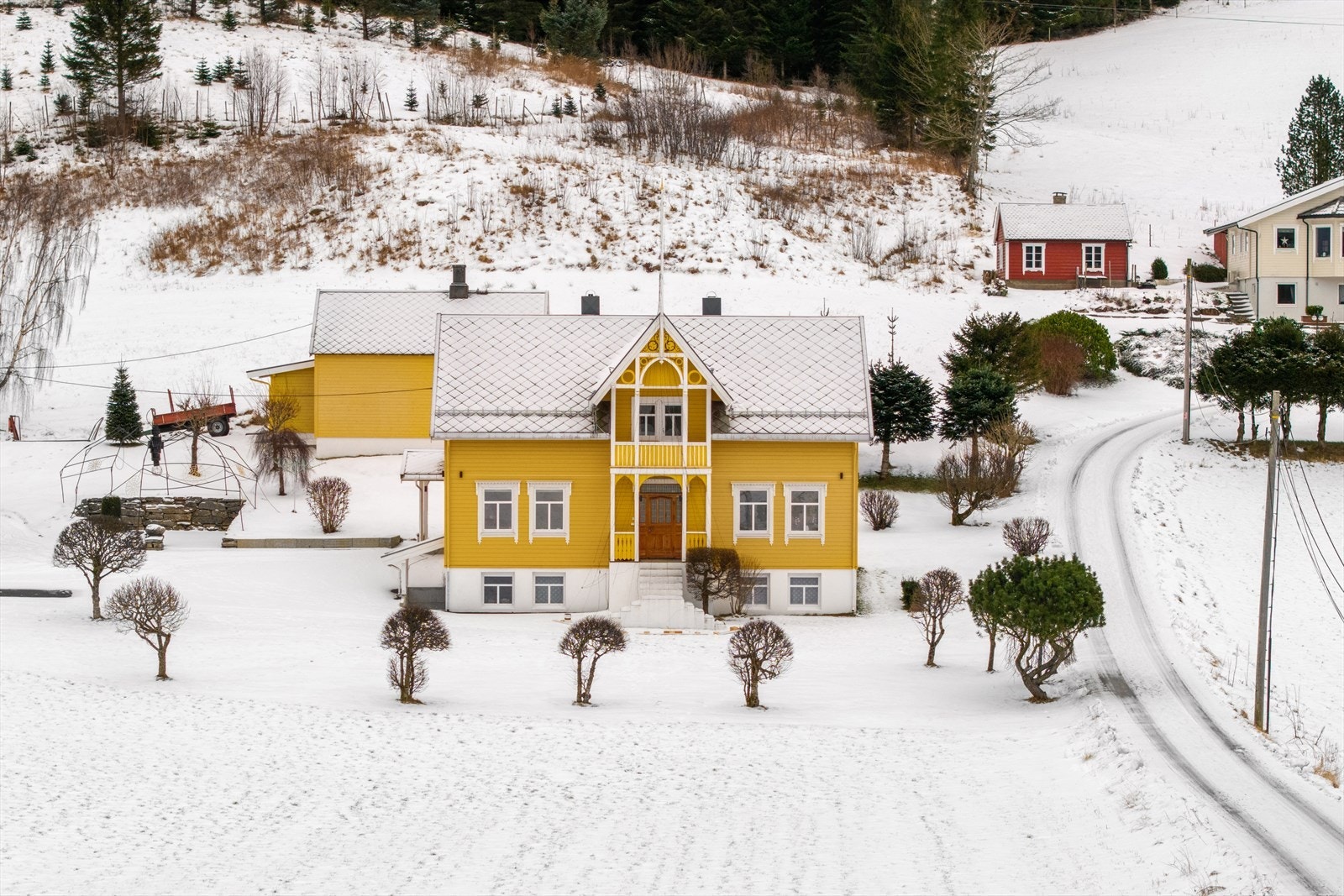Oversiktsbilde som viser hovedhuset sentralt plassert på det snødekte tunet. Galleribilde