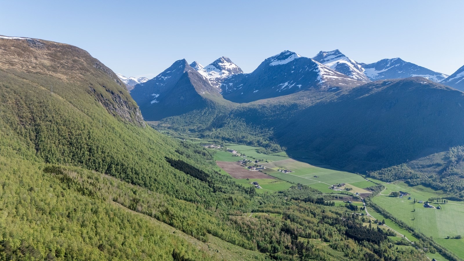De spisse toppene i Romsdalsalpene er synlige i horisonten. Galleribilde