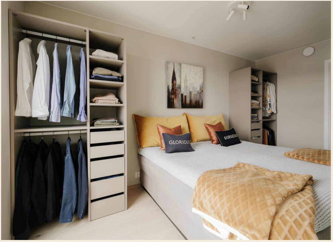 Smart innredet soverom med garderobe på hver side av dobbeltsengen Galleribilde