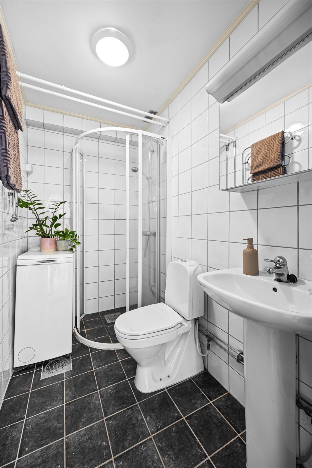 Badet er utstyrt med dusjhjørne, servant, toalett og speilskap med belysning. Galleribilde