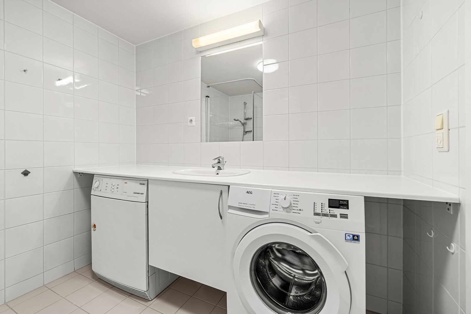 Badet er utstyrt med benkeplate med servant og opplegg for vaskemaskin. Galleribilde