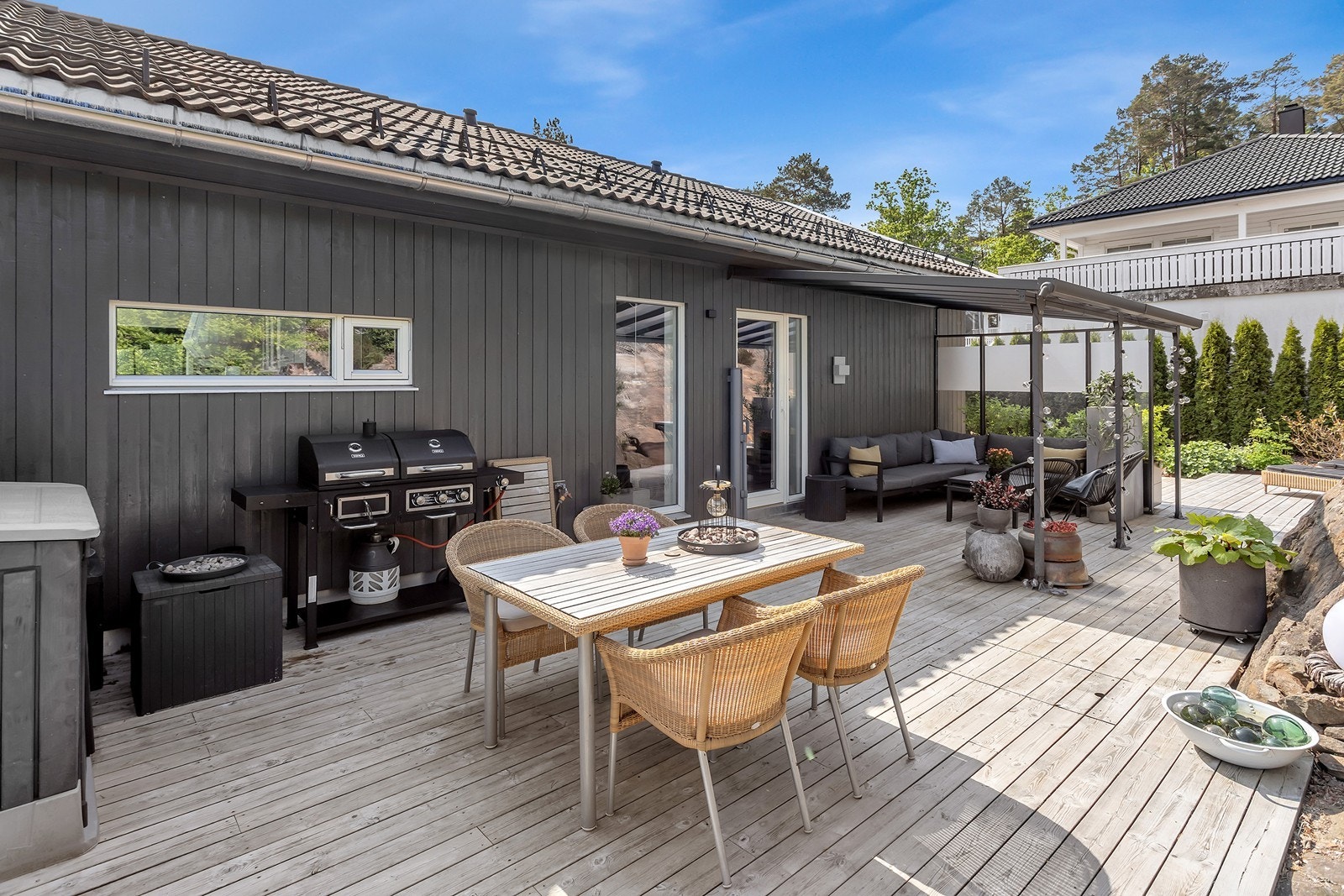 Skjermet og hyggelig uteplass med god plass til både spisegruppe, grill og lounge under tak. Galleribilde