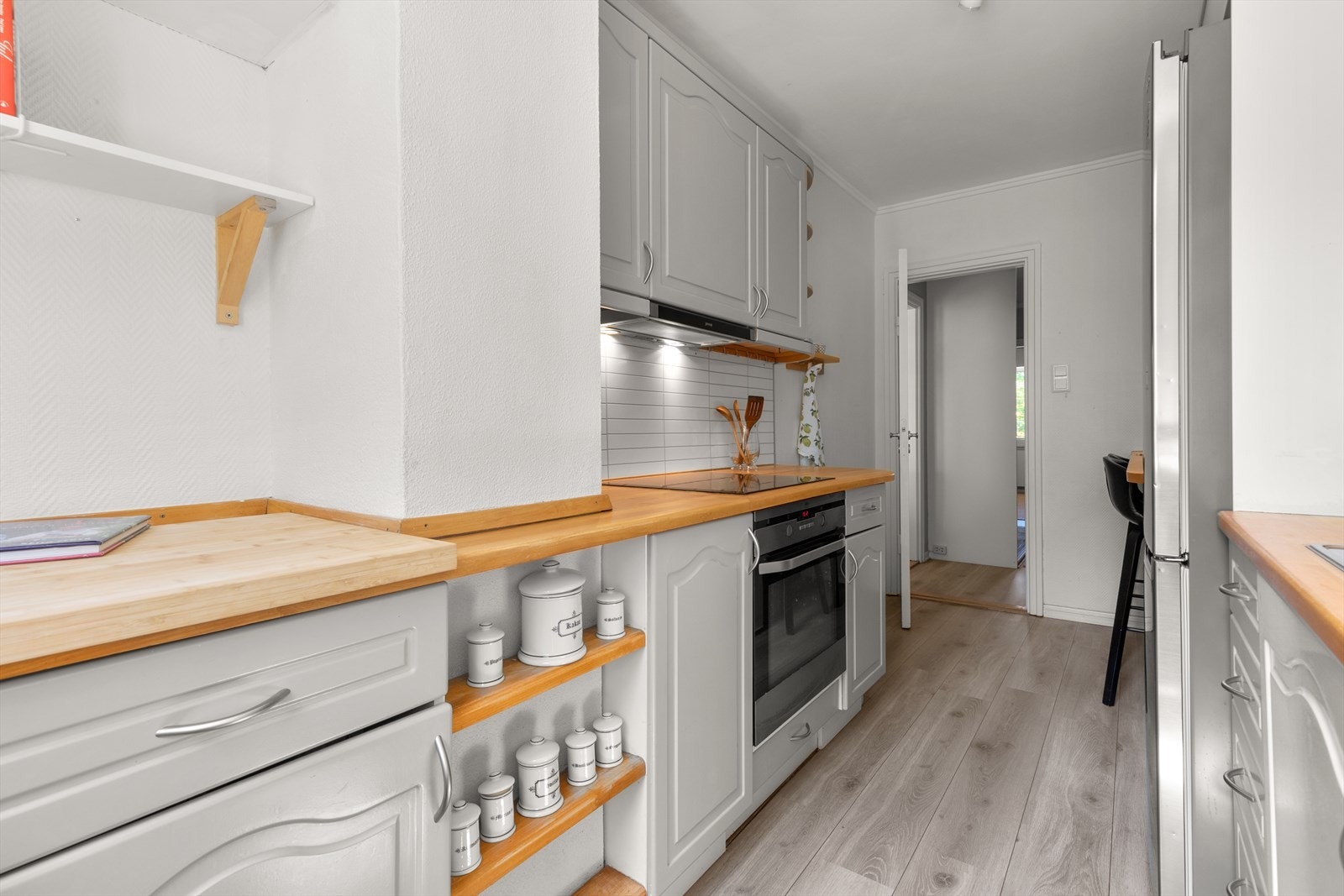 Kjøkkeninnredningen har profilerte fronter og benkeplate i tre. Det er opplegg for oppvaskmaskin. Galleribilde