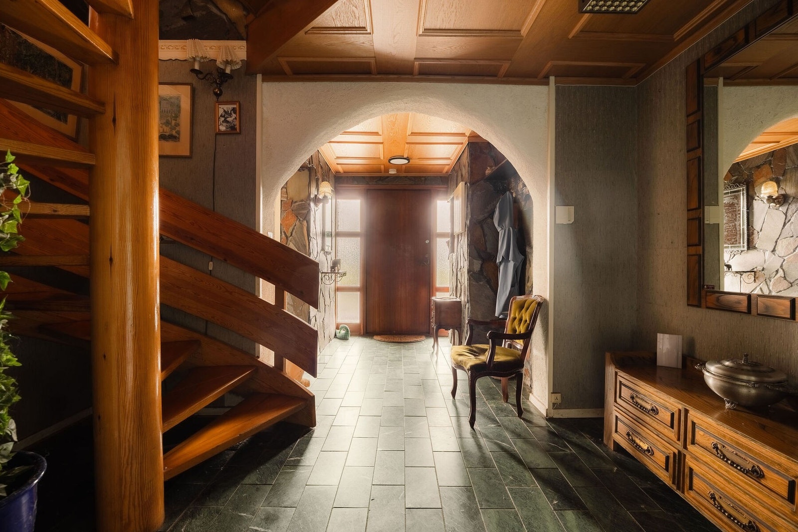 Velkommen inn. Inne venter en stor hall med naturmaterialer, skifergulv, og detaljer i tre. Galleribilde