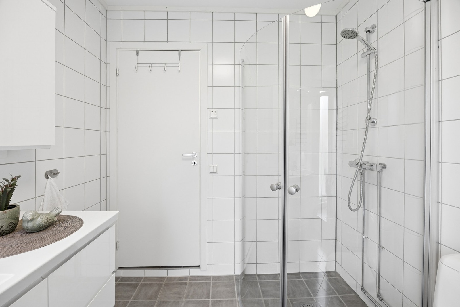 Badet er utstyrt med dusjhjørne med innfellbare glassdører. Galleribilde