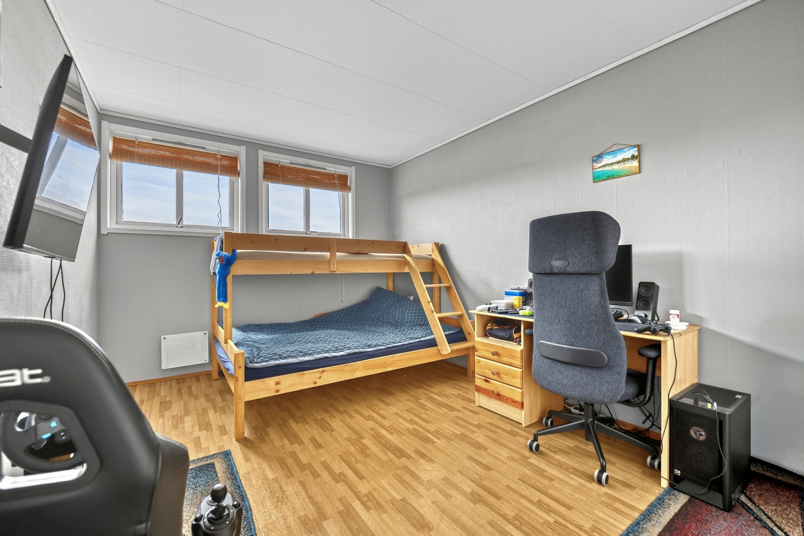 To av leilighetens tre soverom ligger i 2. etasje, og begge har gråmalte vegger og gyllent laminatgulv. Galleribilde