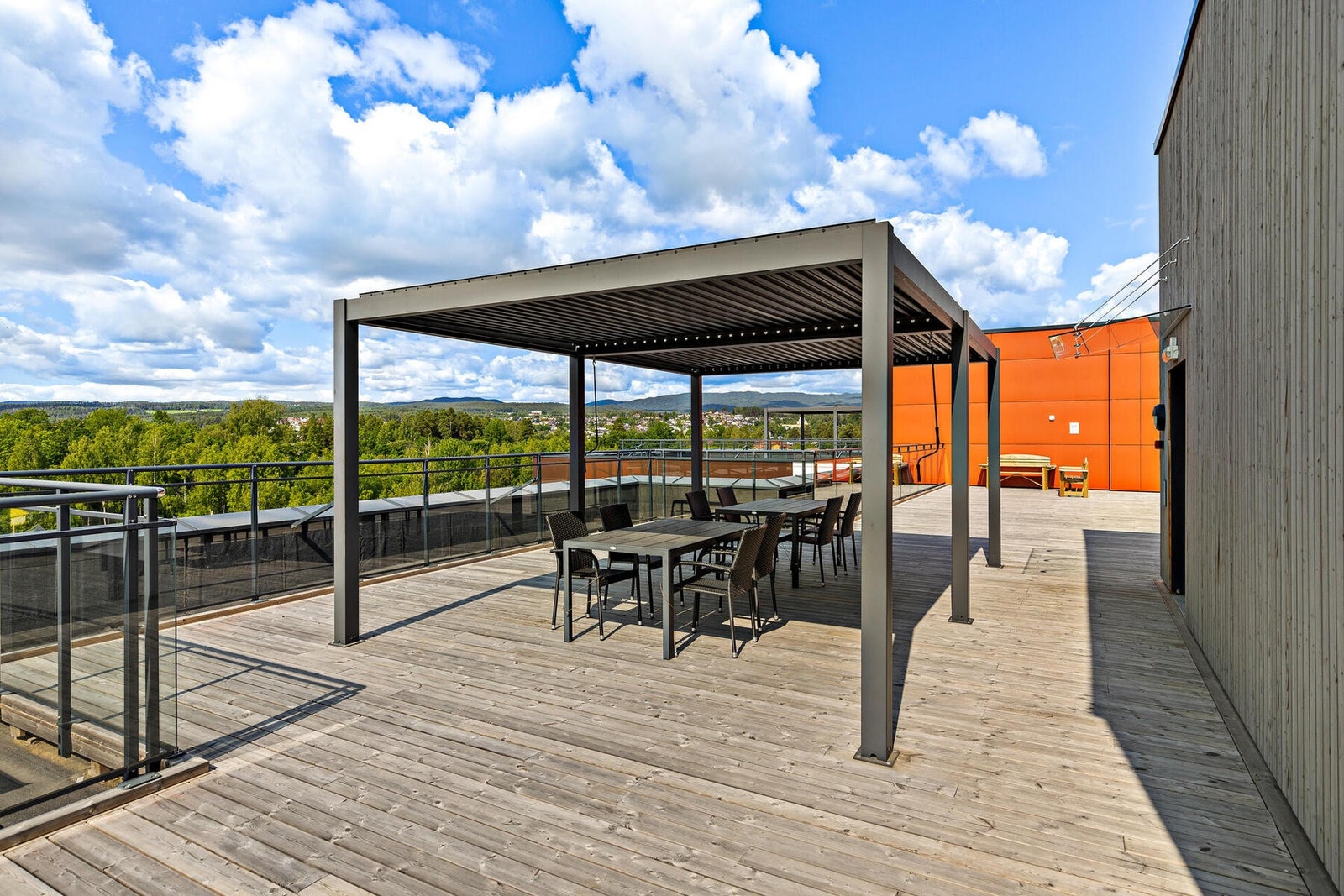 Videre er det en felles, solrik takterrasse med utemøbler og pergola Galleribilde