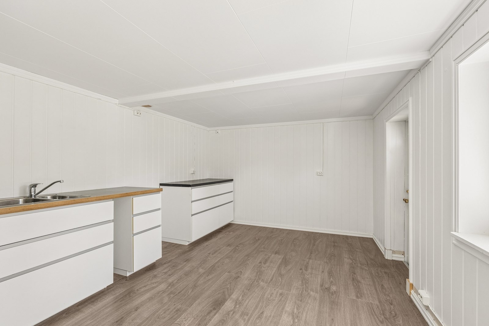 Kjøkkeninnredning med glatte fronter og benkeplate i laminat. Galleribilde