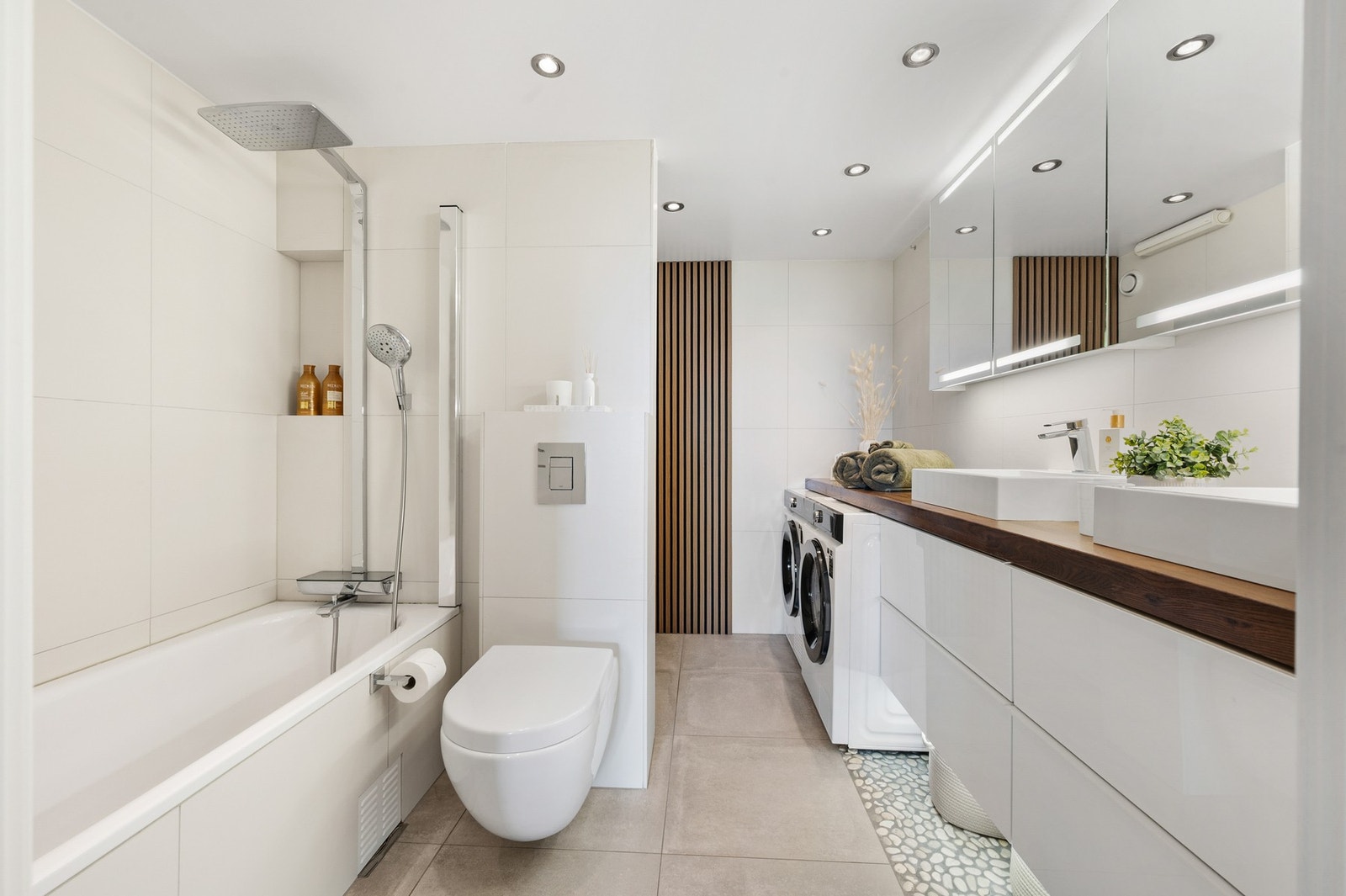 Badet har også badekar, vegghengt toalett og praktiske løsninger for en komfortabel hverdag. Galleribilde