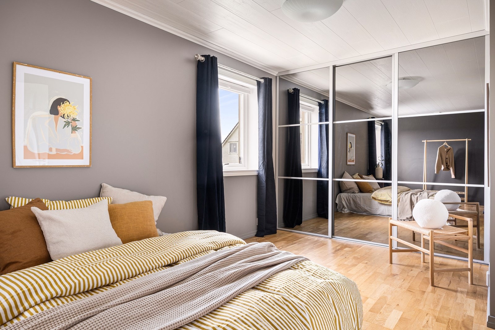En stor skyvedørsgarderobe med speilfronter gir rikelig med oppbevaringsplass. Galleribilde