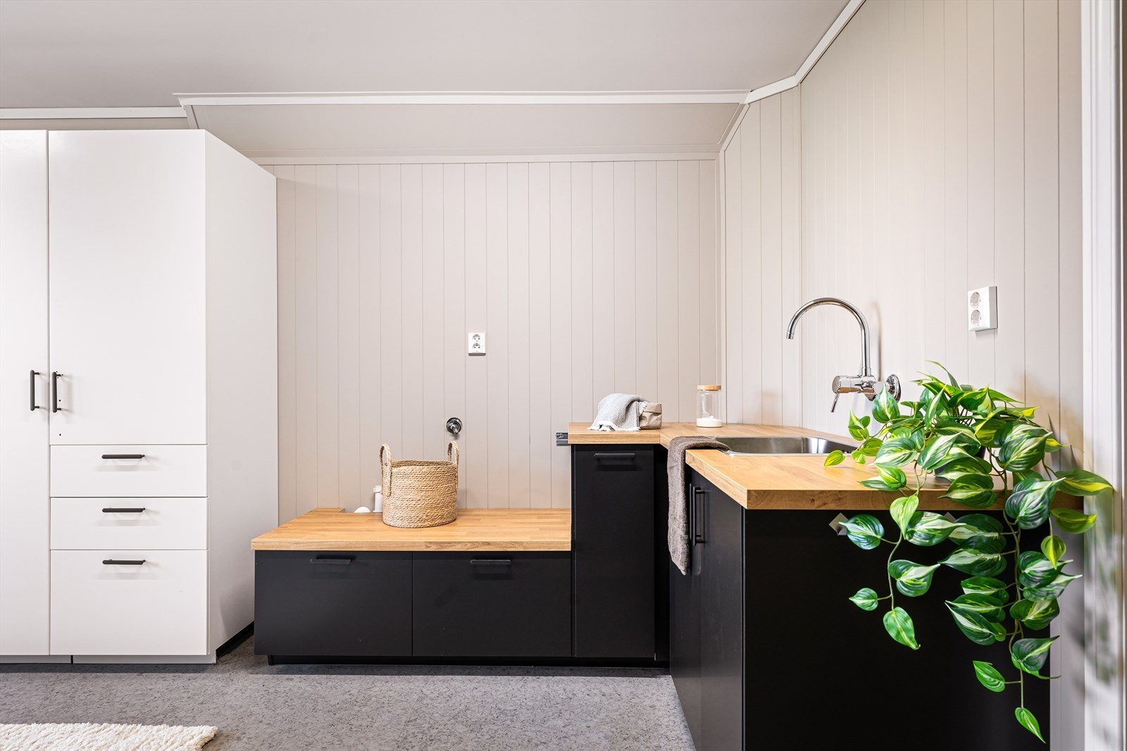 Stort og praktisk vaskerom med gulvbelegg, laminerte benkeplater og opplegg for vaskemaskin. Galleribilde