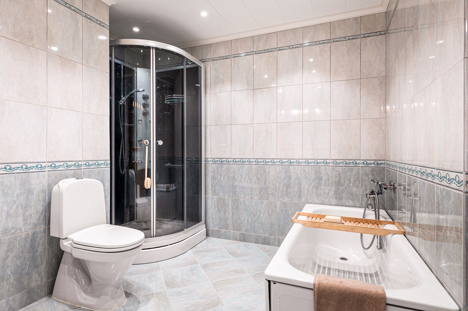 Det romslige badet i underetasjen er utstyrt med både badekar og dusjkabinett. Galleribilde