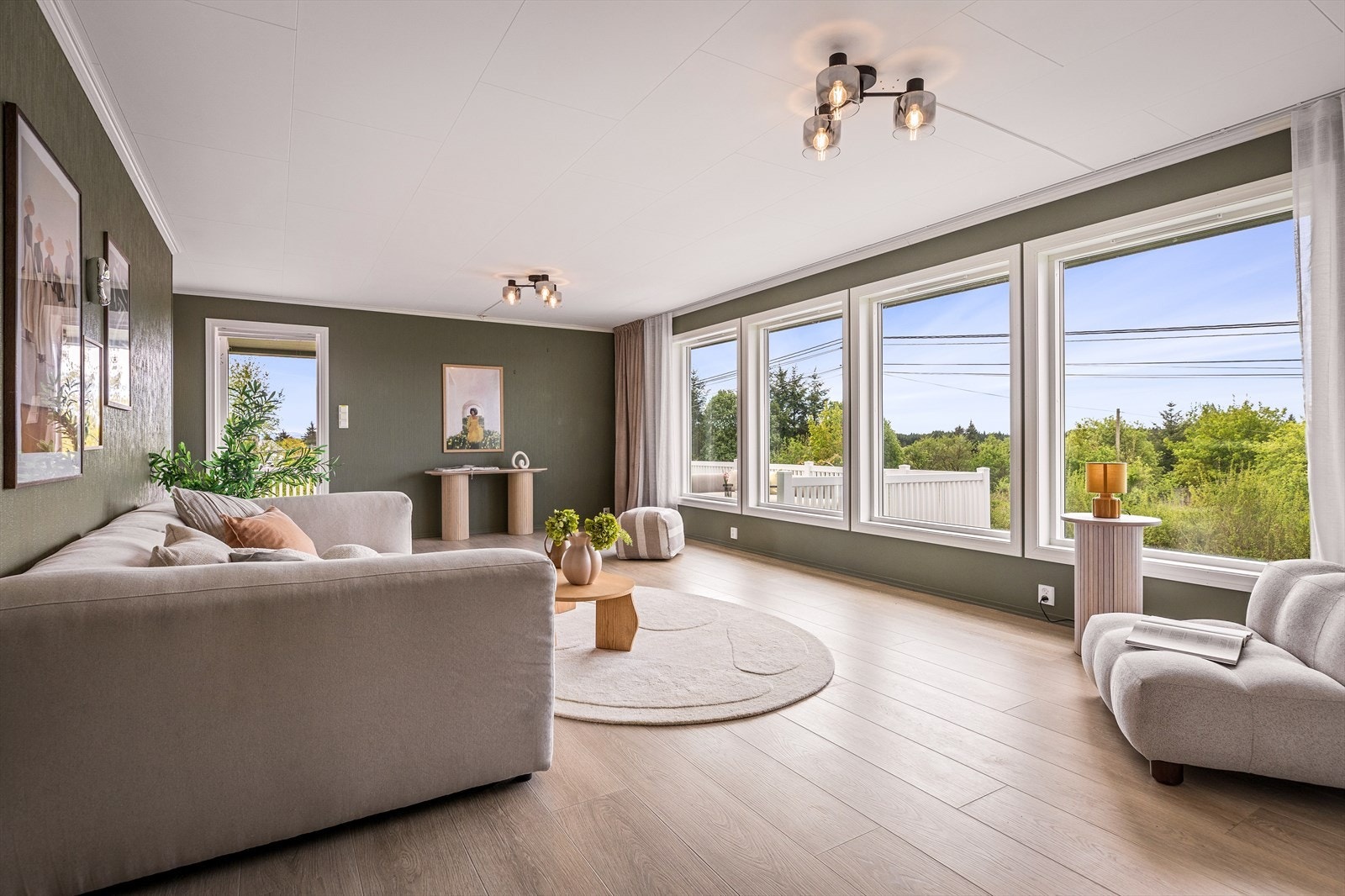 Stuen i overetasjen er lys og romslig, med plass til en stor sofagruppe. Galleribilde