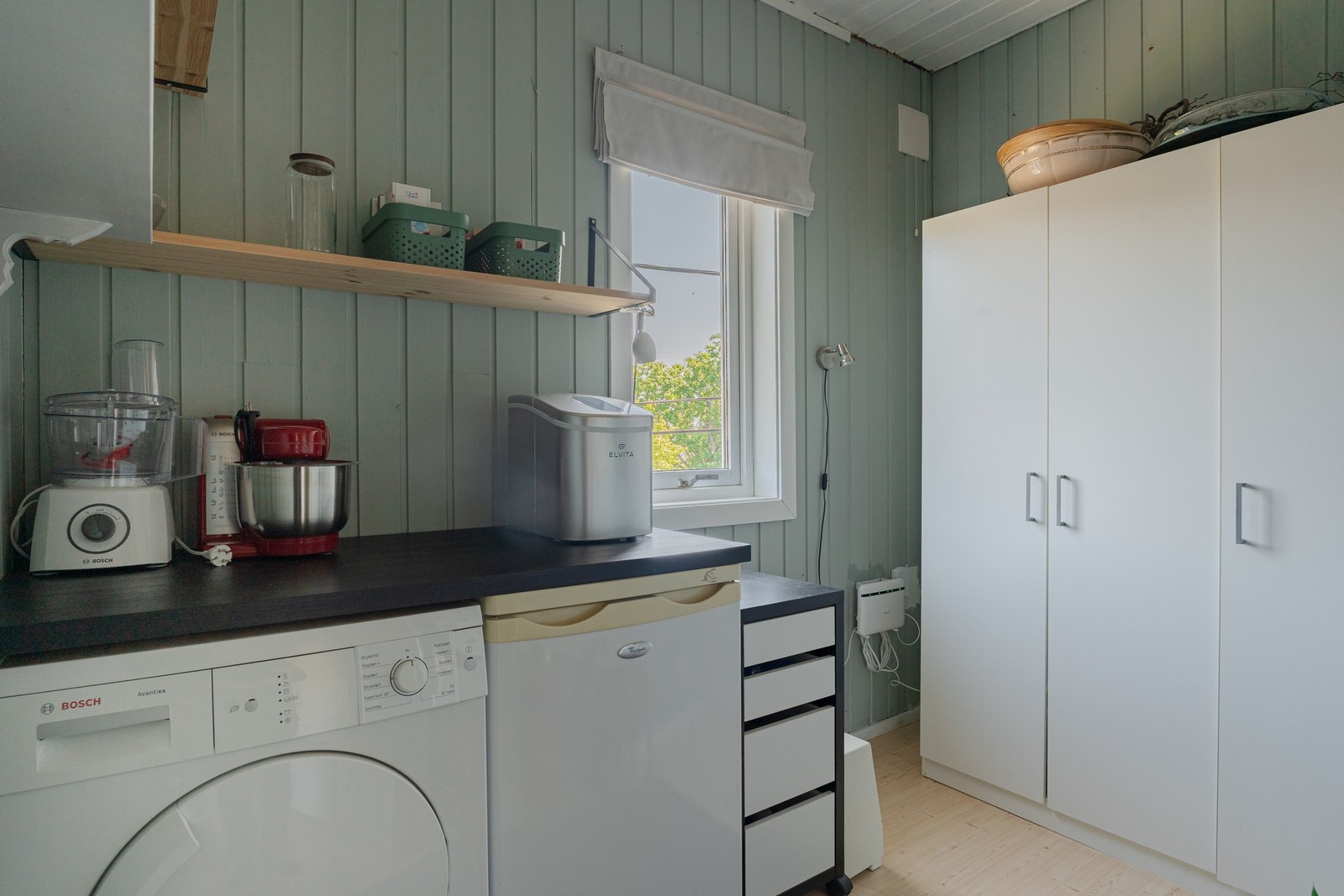 Innenfor soverommet ligger det en bod, praktisk innredet med skap, tørketrommel og fryser. Galleribilde