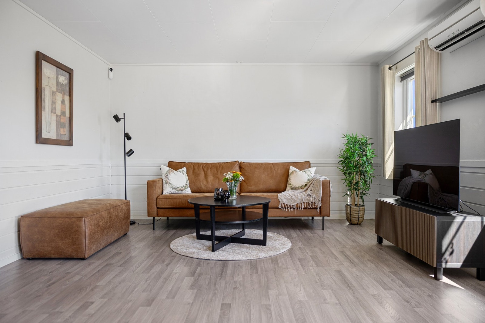 Den effektive planløsningen gir gode møbleringsmuligheter med plass til en stor sofagruppe i TV-stuen. Galleribilde