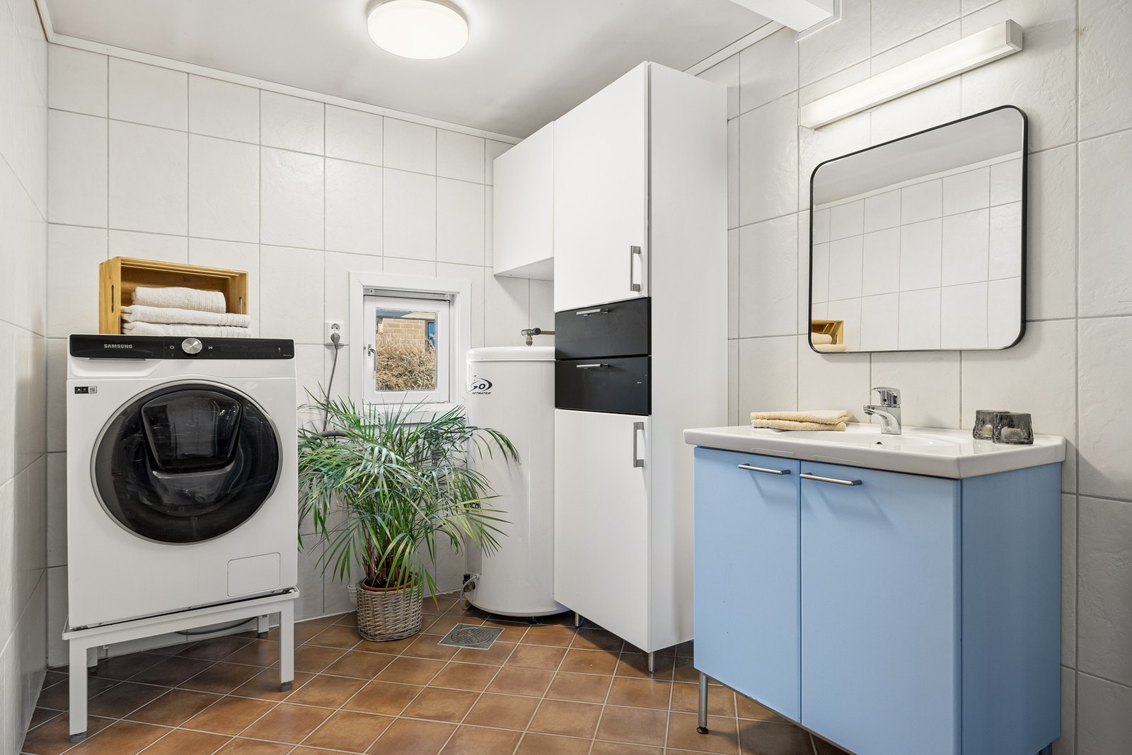 Badet har gode oppbevaringsmuligheter i høyskap, samt god plass til både vaskemaskin og tørketrommel. Galleribilde