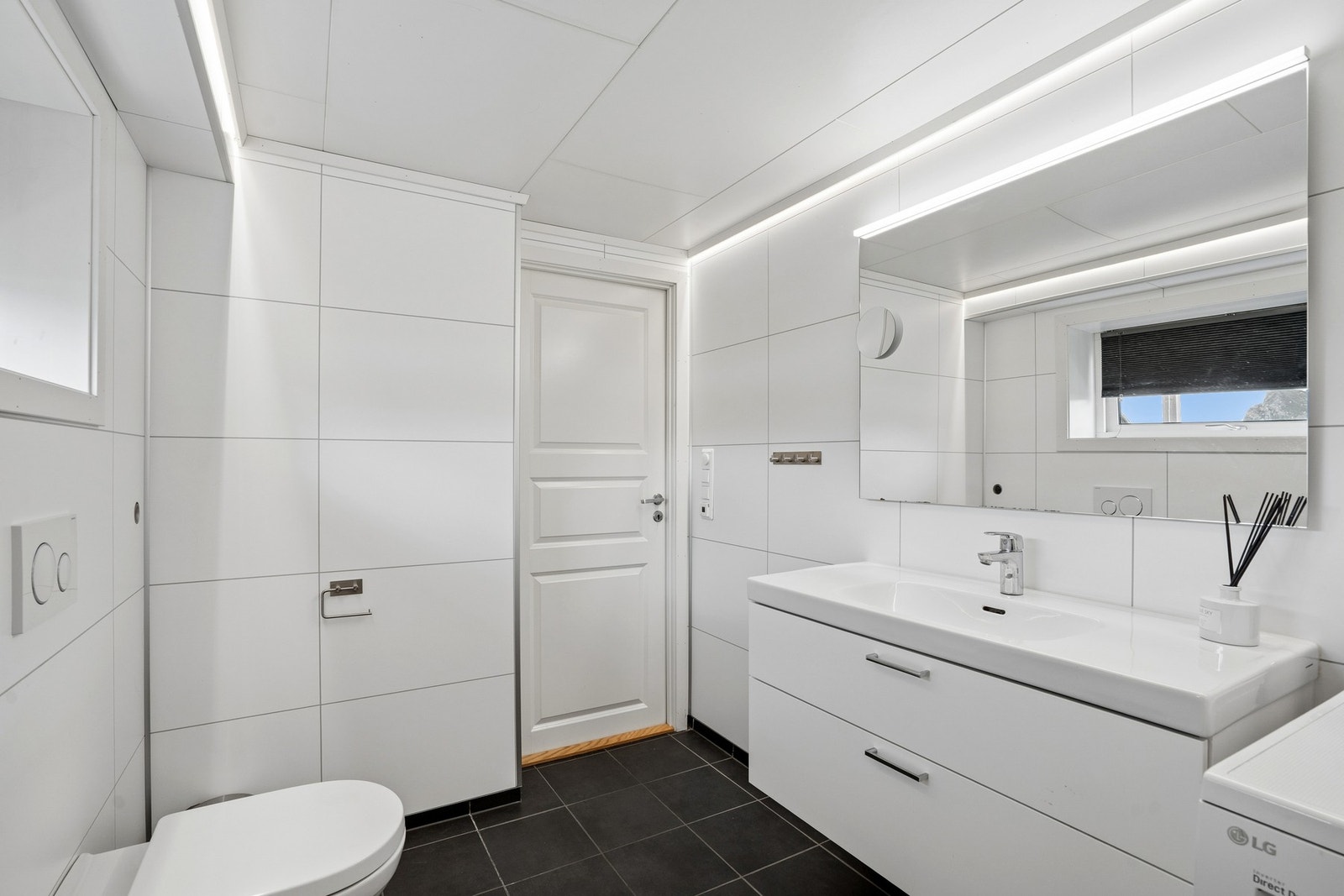 Badet i kjelleren har innredning med servant, veggmontert toalett og godt med skapplass. Galleribilde