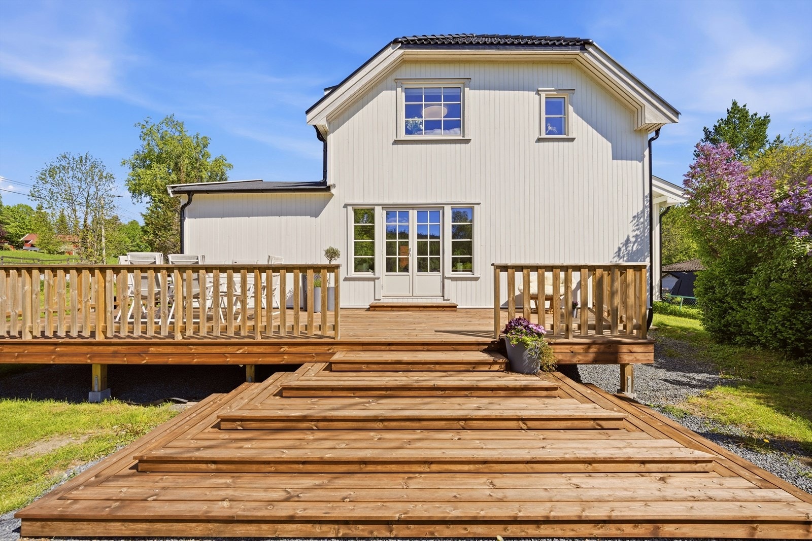 Pyramidetrapp ned til romslig hage med gode sittemuligheter for mange personer Galleribilde