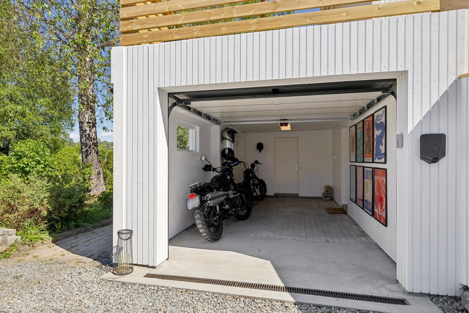 Integrert garasje med ny elektrisk leddport fra 2026 og elbillader montert på yttervegg. Galleribilde
