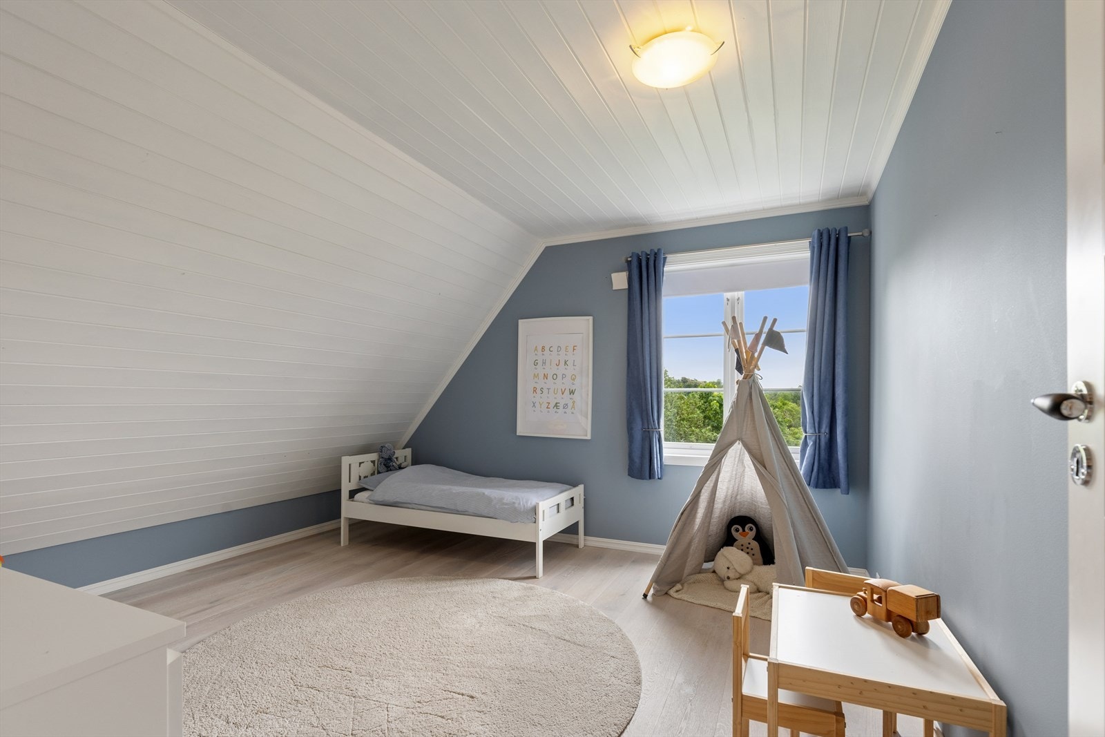 Soverom med sjarmerende skråtak og malt panel i himling. Galleribilde
